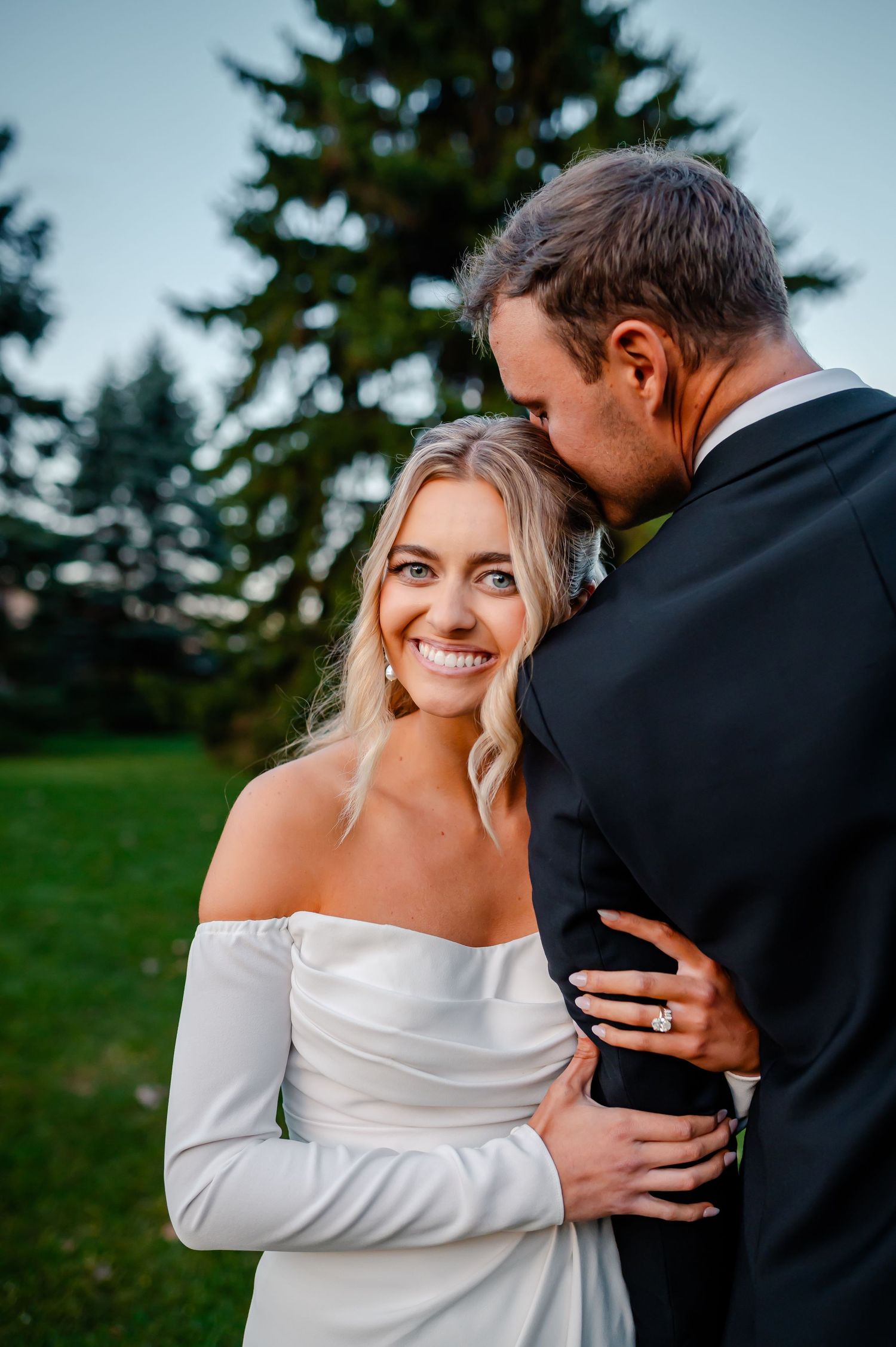 A series of intimate wedding photos showing a couple embracing outdoors against a backdrop of evergreen trees.