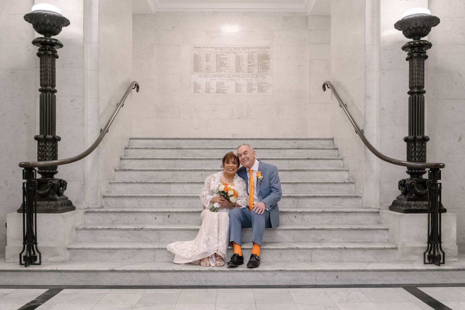 A bride and groom standing together and smiling on their wedding day.