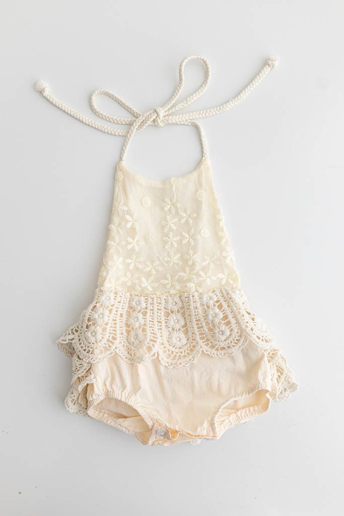 Cream lace halter baby romper for baby's first birthday photography session.