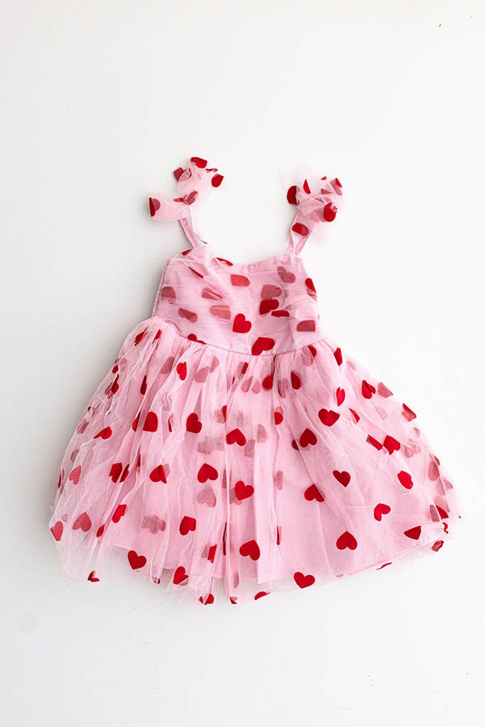 Pink tulle toddler girls dress with red heart print pattern and ruffle straps, perfect for Valentine's Day.