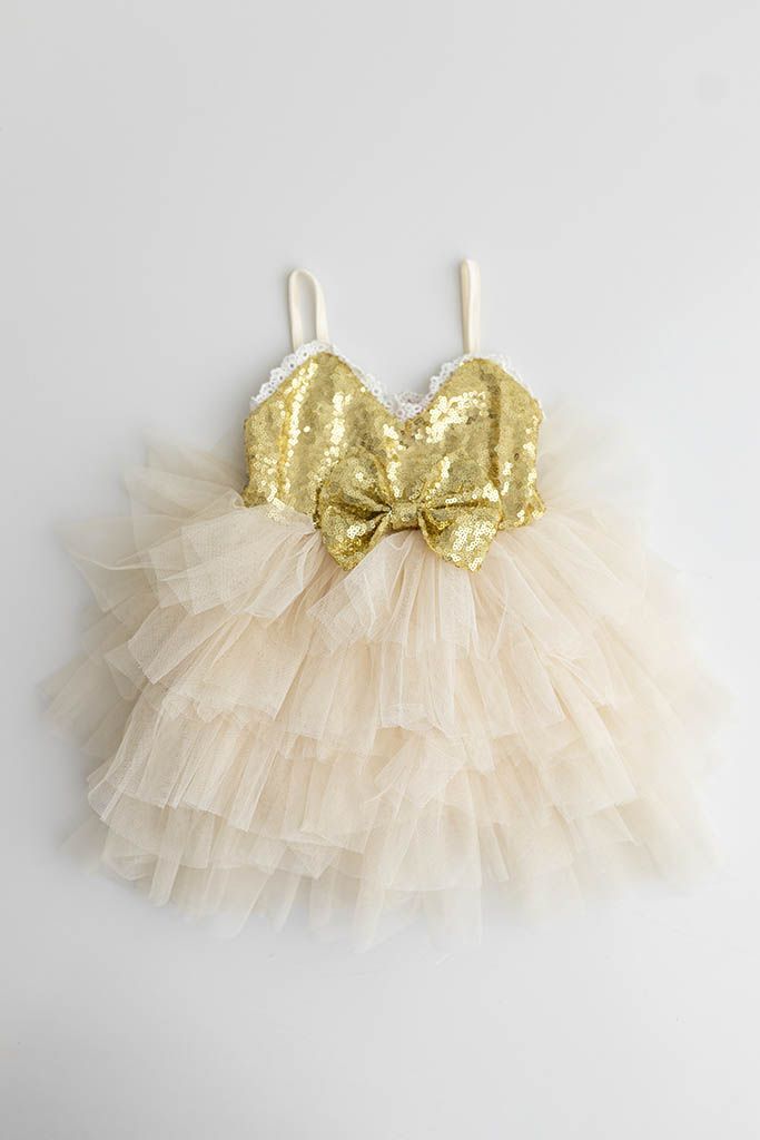 Dressy outfit for babies first birthday photoshoot: Gold sequin bodice baby girls dress with cream tiered tulle skirt and bow detail.