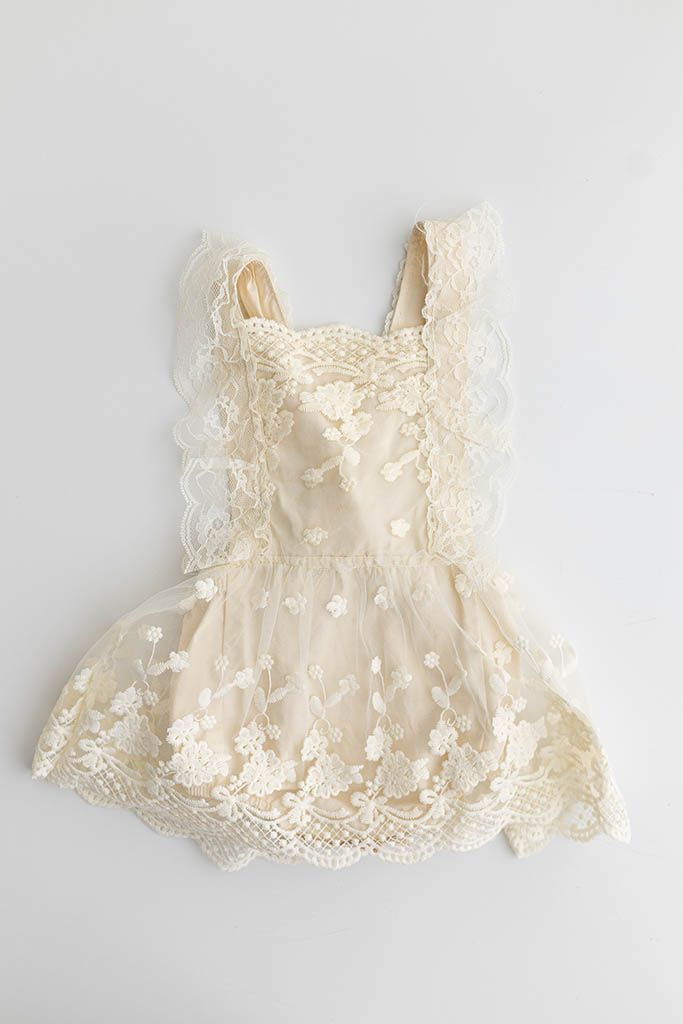 Ivory lace flutter sleeve baby dress with floral embroidery and scalloped hem detail.