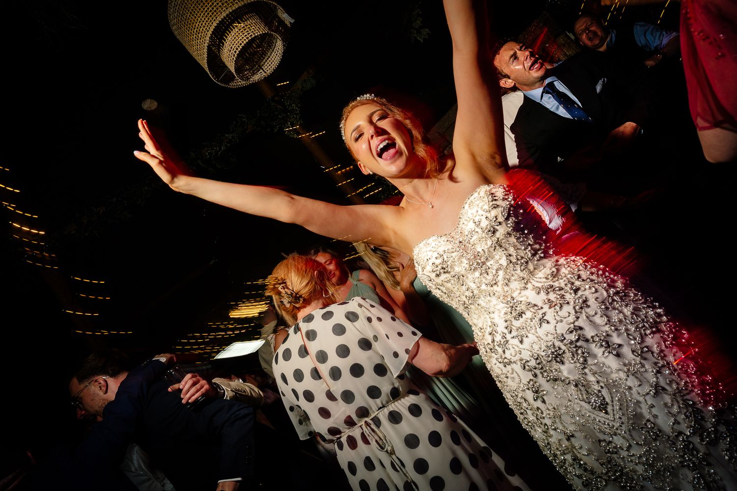 Wedding party dancing and celebrating on a dark dance floor. Woodhill Hall.