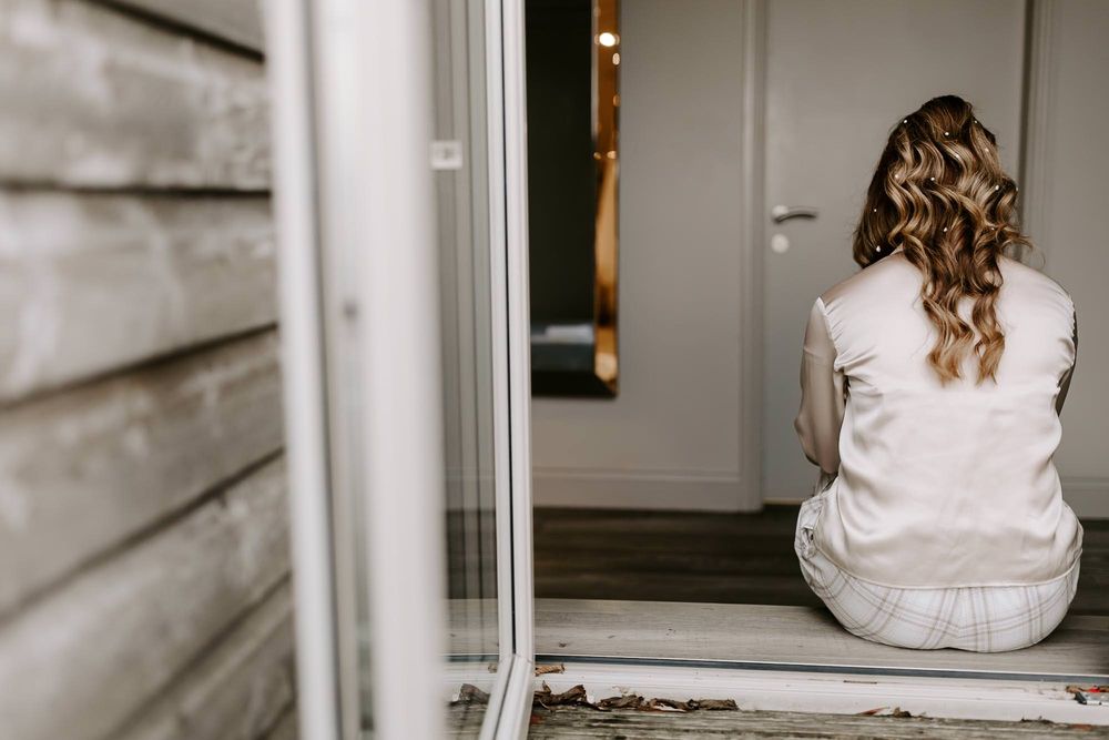 Black and white photo series showing someone in a white dress sitting on steps in different poses.