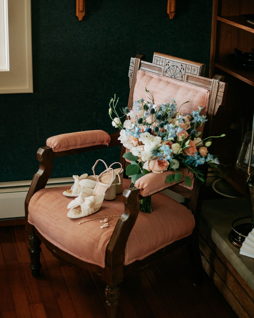 Delicate blue and white floral bouquets rest on a vintage pink velvet chair.