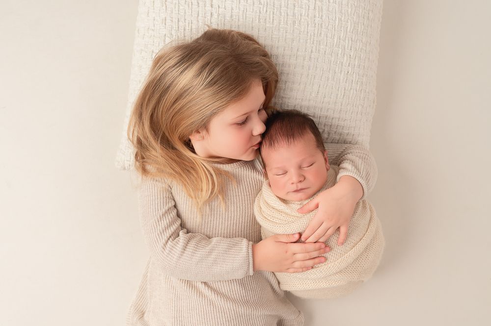 A tender newborn photography session with soft neutral tones and gentle poses.