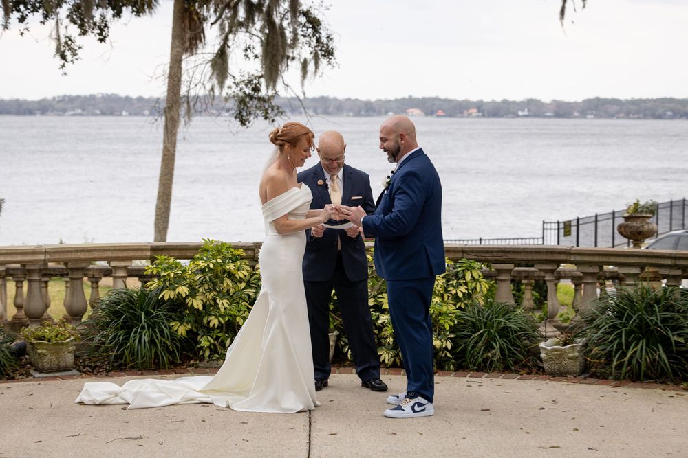 A coastal wedding ceremony setup overlooking a serene waterfront with Spanish moss draped trees.