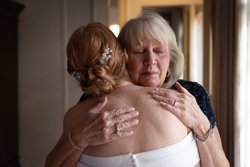 Emotional moment during a wedding ceremony as guests embrace and share heartfelt reactions.