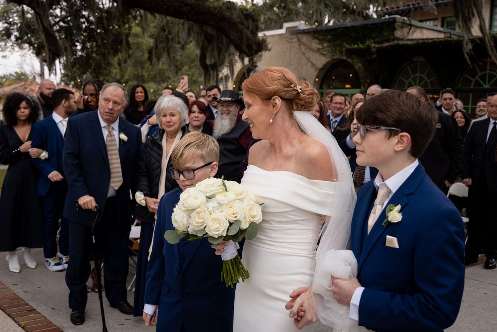 A series of wedding photos showing candid moments between couples in navy blue and white attire during an outdoor celebration.