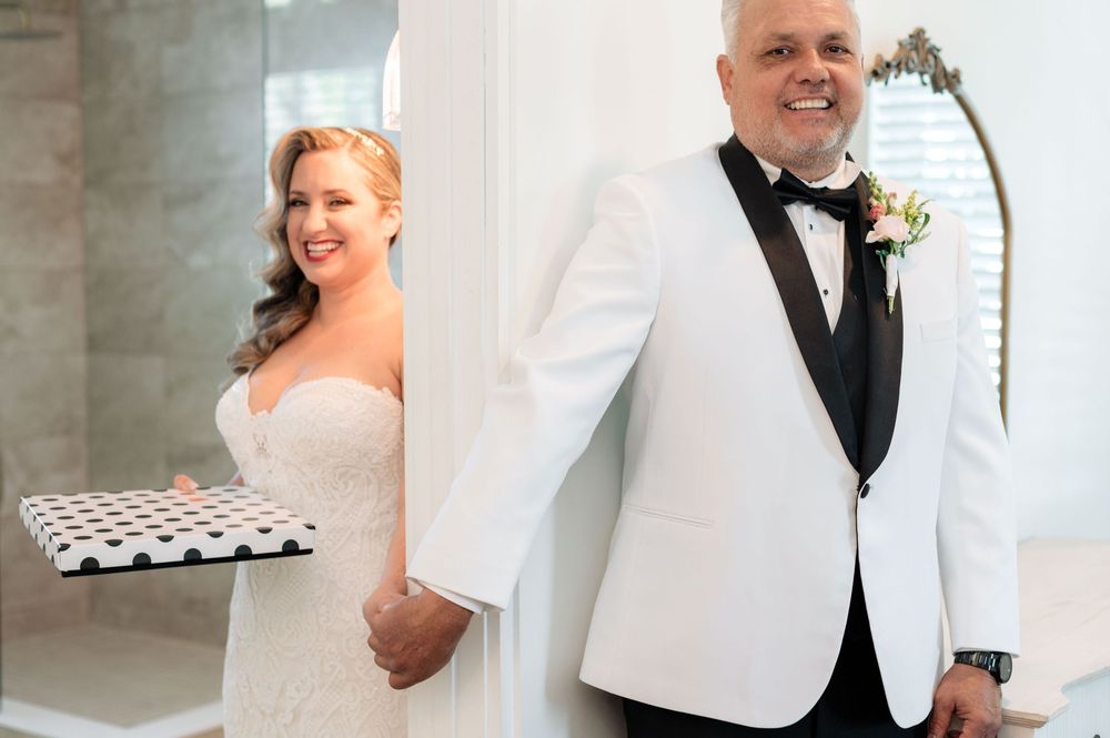 Wedding party members in formal attire pose together at an elegant venue.