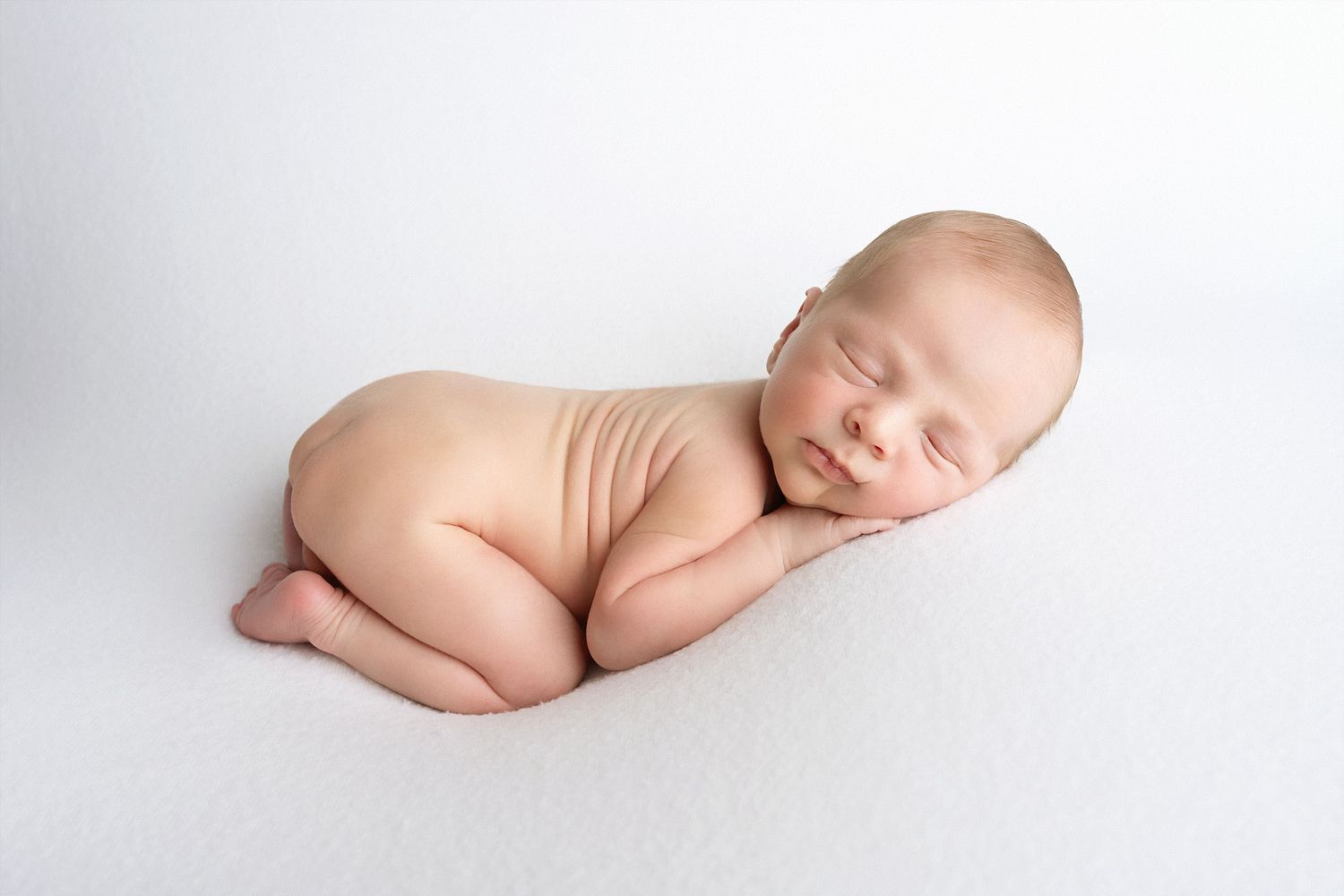 Series of artistic black and white newborn portraits showing different sleeping poses on white background.