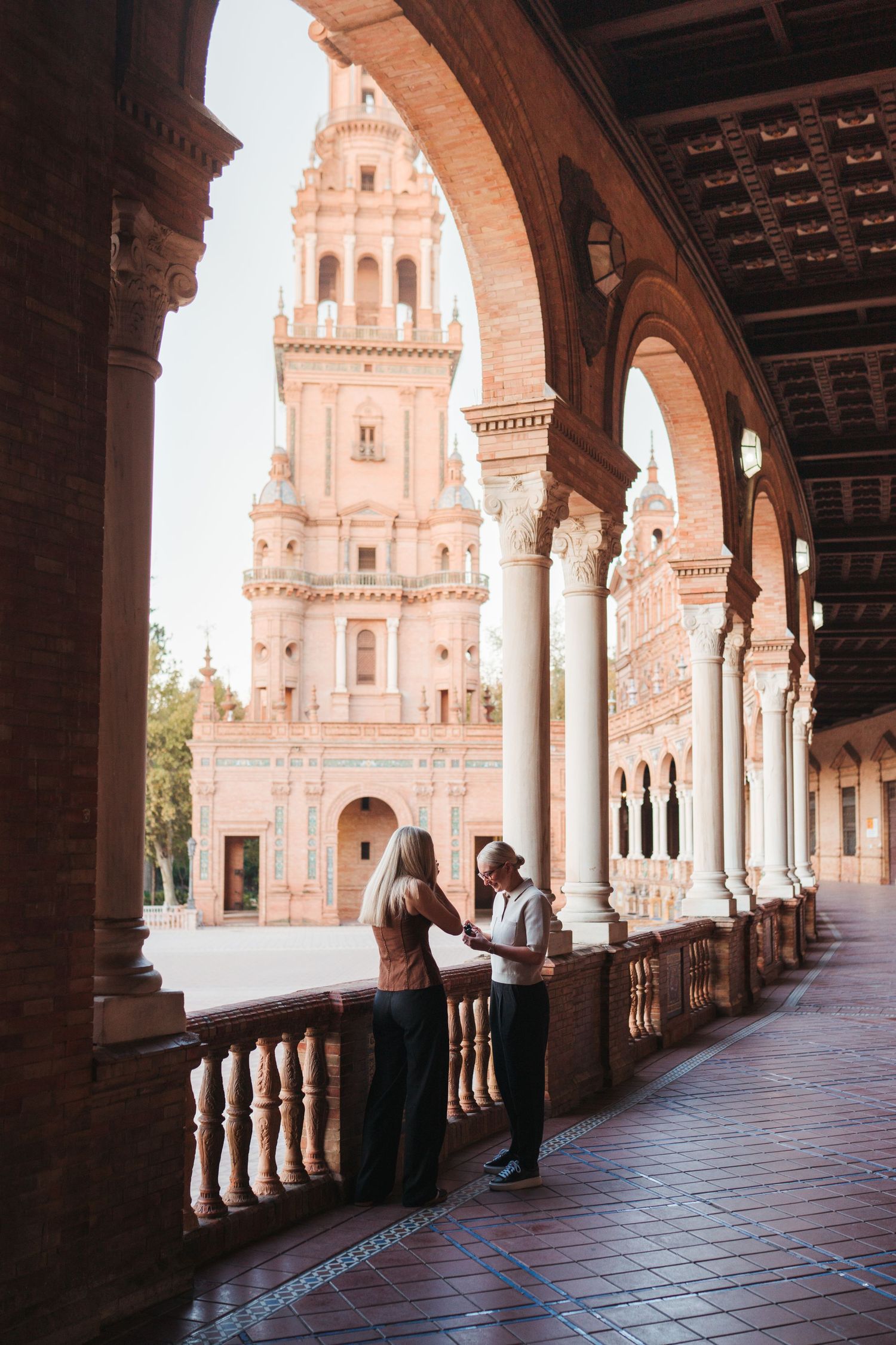 Intimate moment captured at Plaza de España during golden hour with historic architecture.