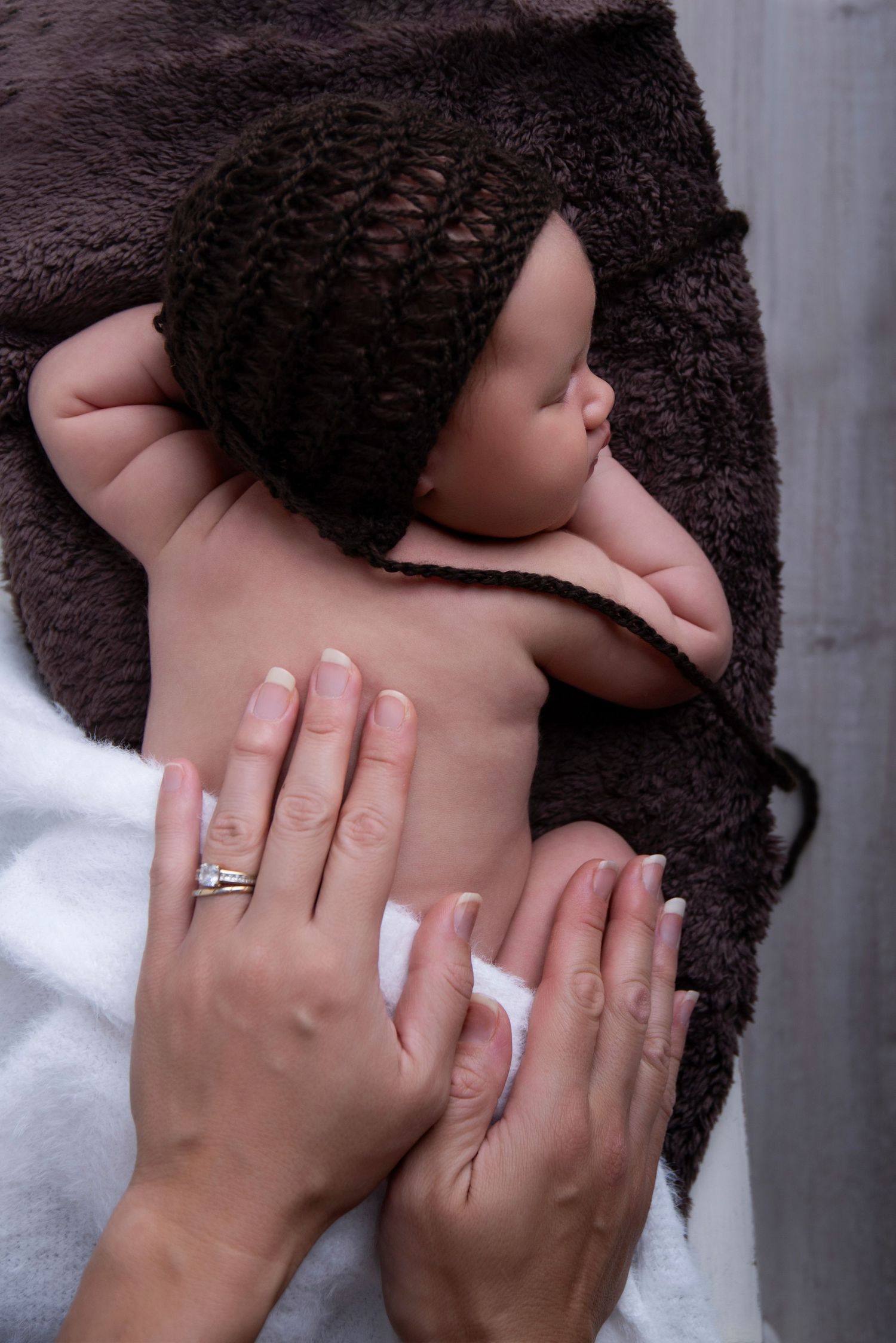baby boy posed in a small bed for is newborn photography session at Genesis Imagery