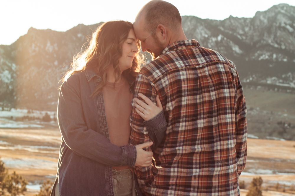 Couple sharing a romantic moment at golden hour with mountain landscape backdrop in warm autumn  | How I Help You Prep for Family Photos