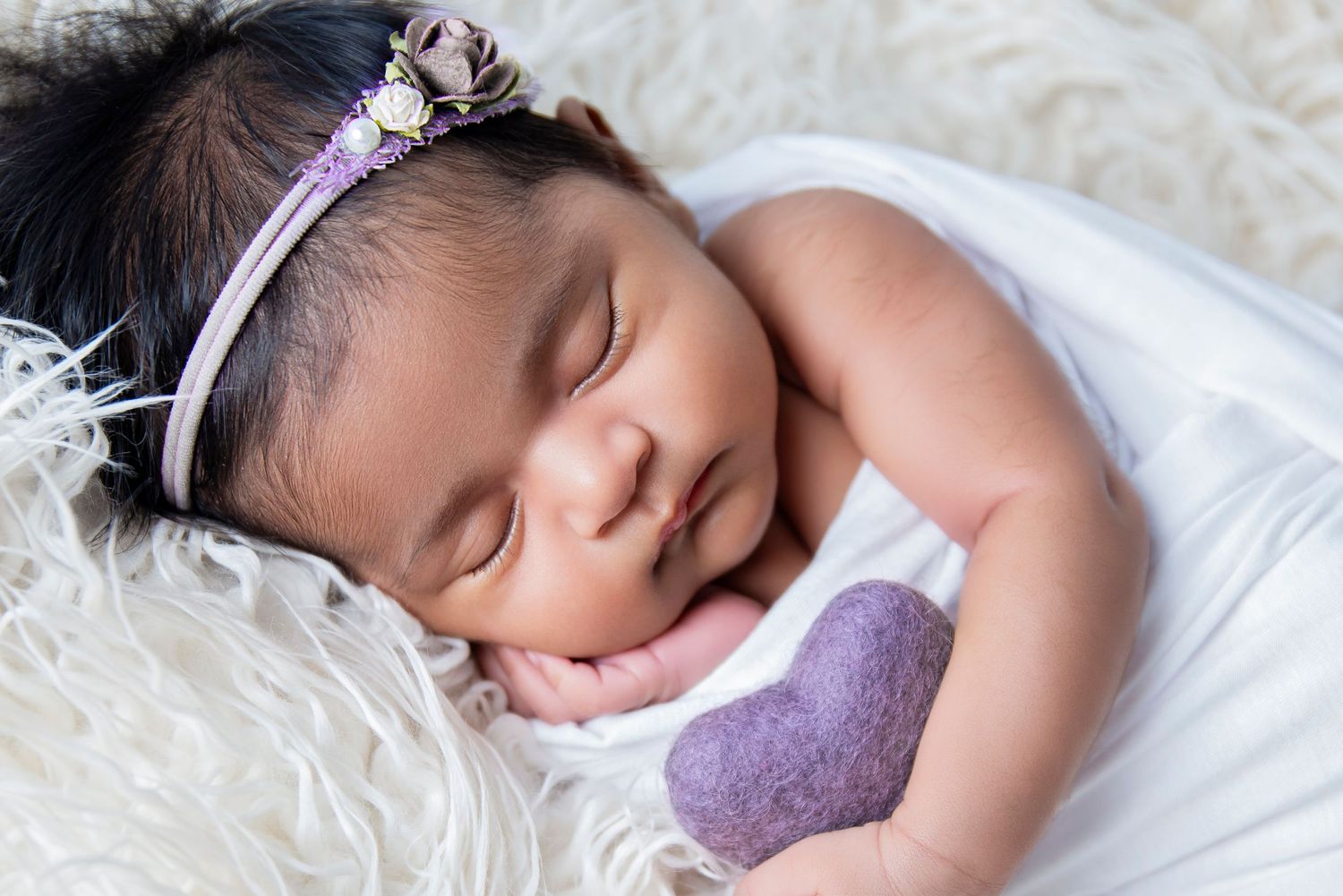 newborn baby girl holding I mini felt purple heart we have all the ports for your newborn session