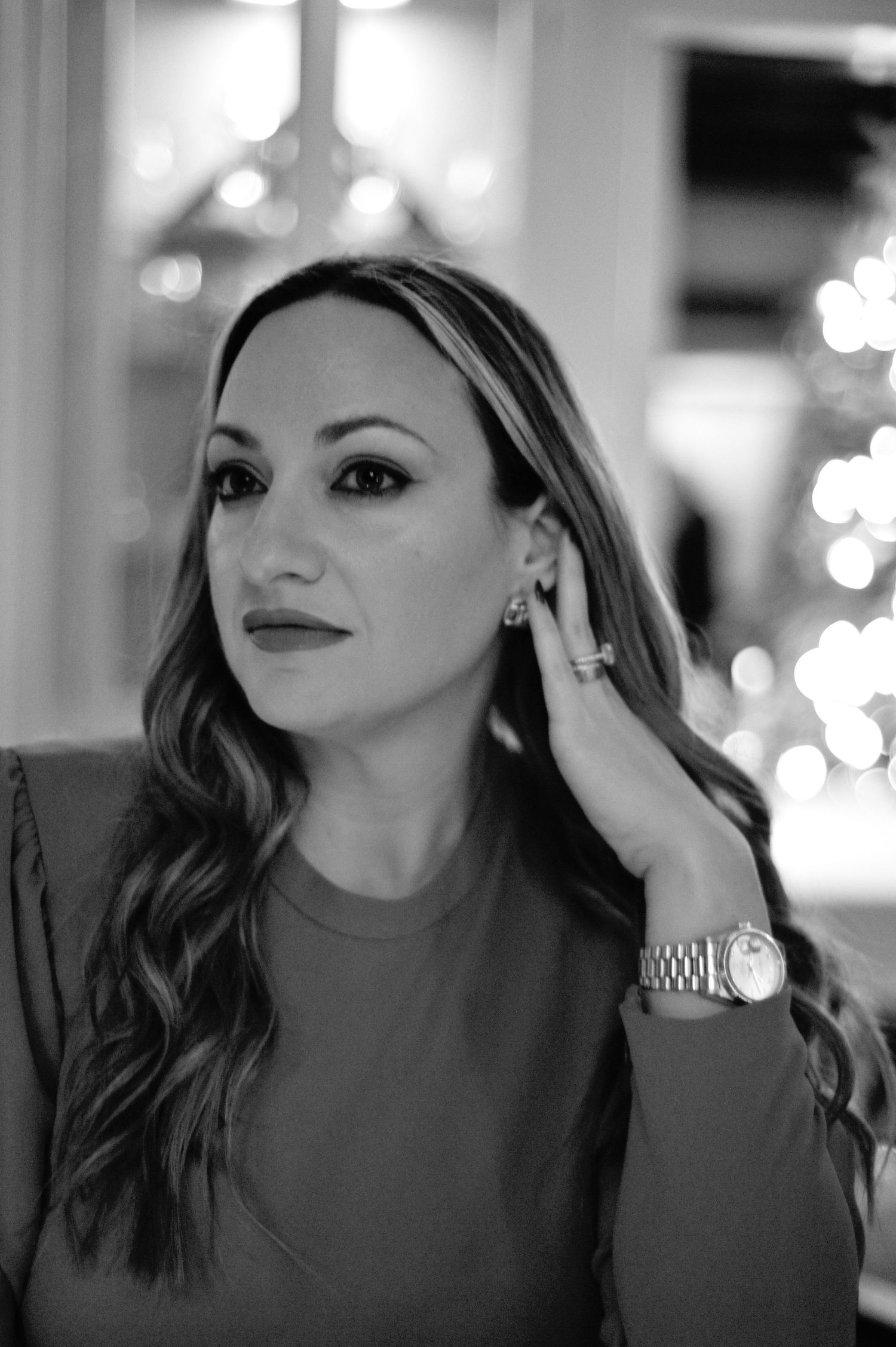 Black and white photo series showing a woman with wavy hair and dark lipstick posing in different angles.