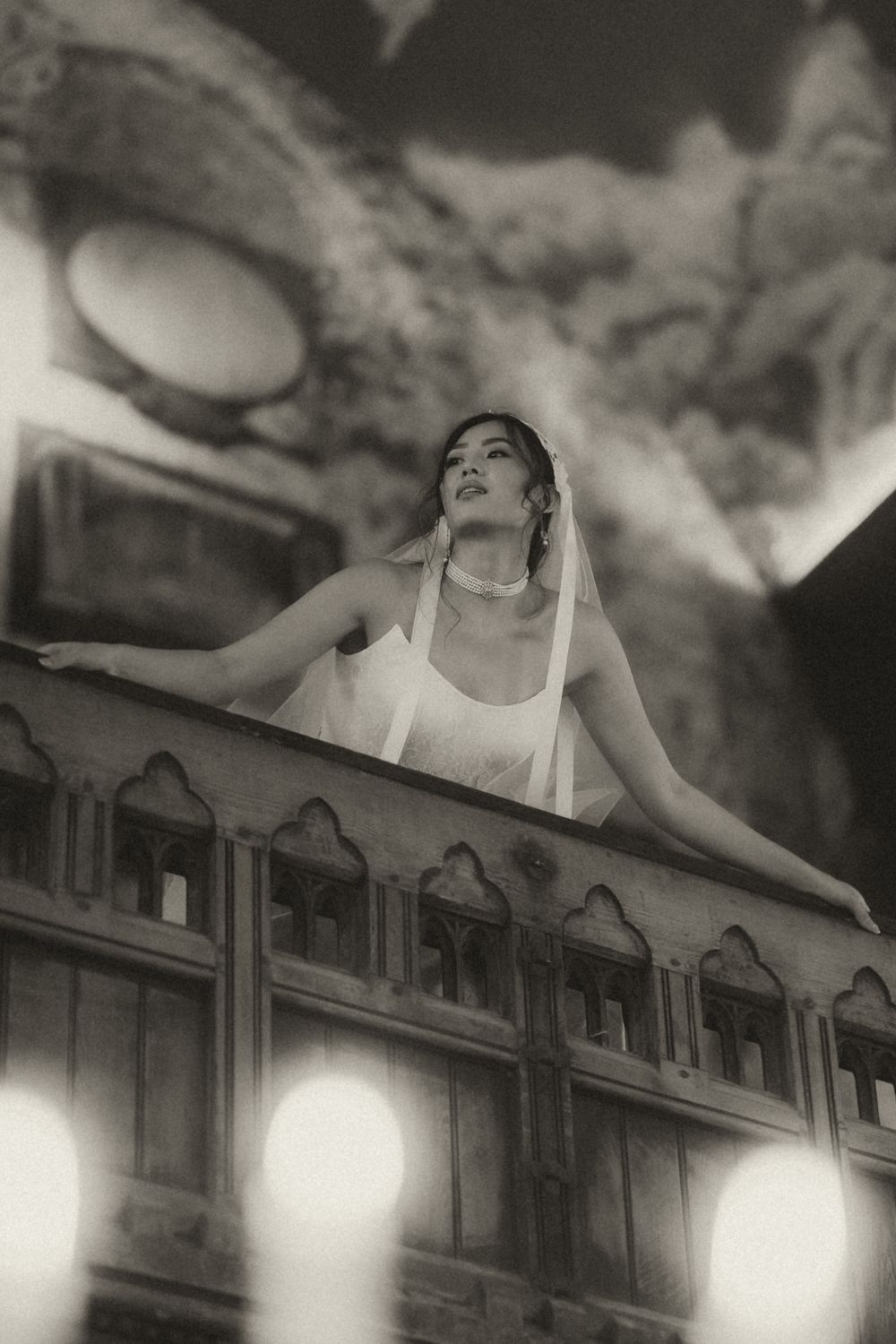 A dramatic black and white photo sequence shows a figure reclining on top of a bookshelf in artistic poses.