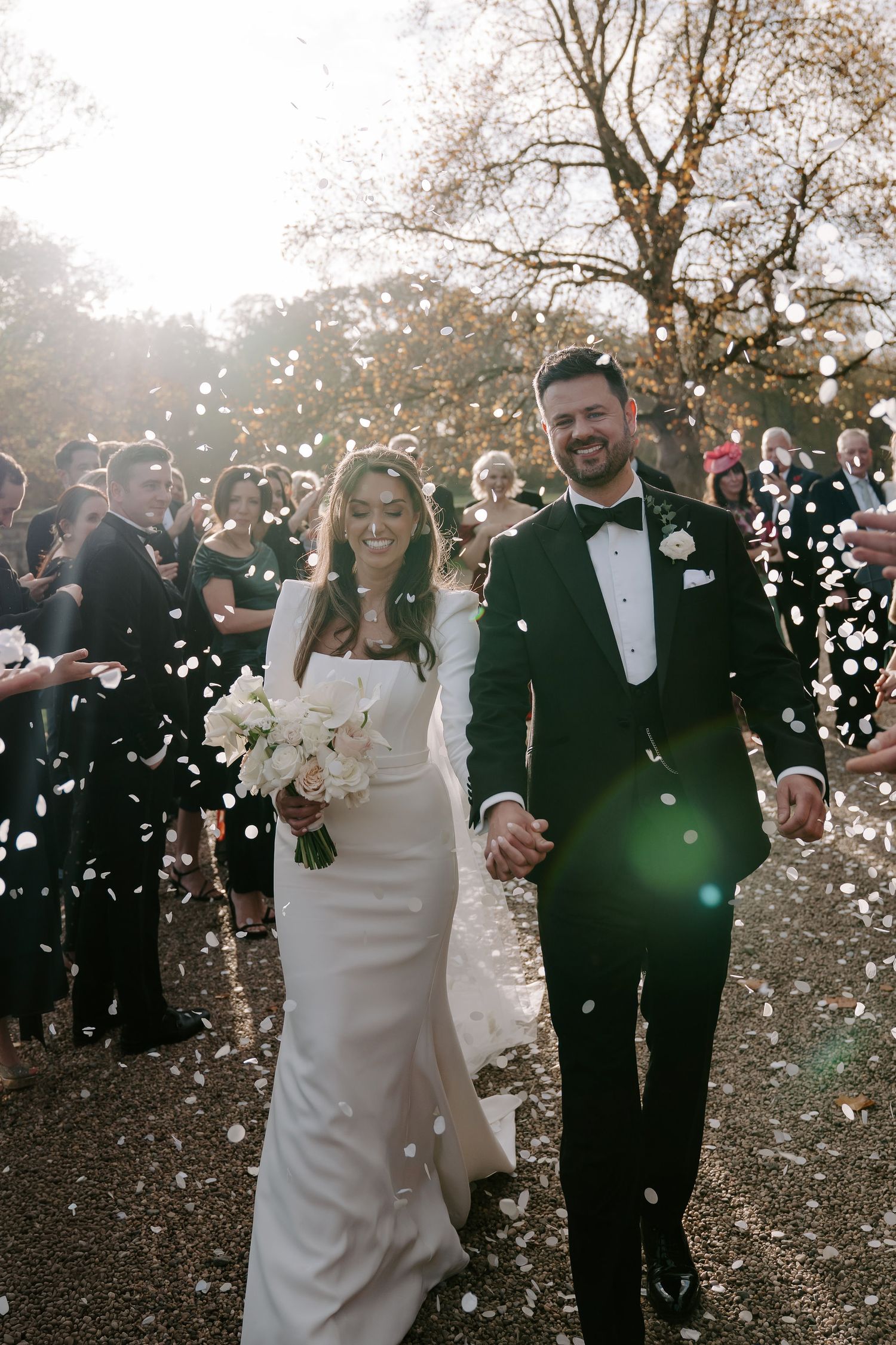 wedding guests throwing confetti over the bride and groom at Iscoyd park