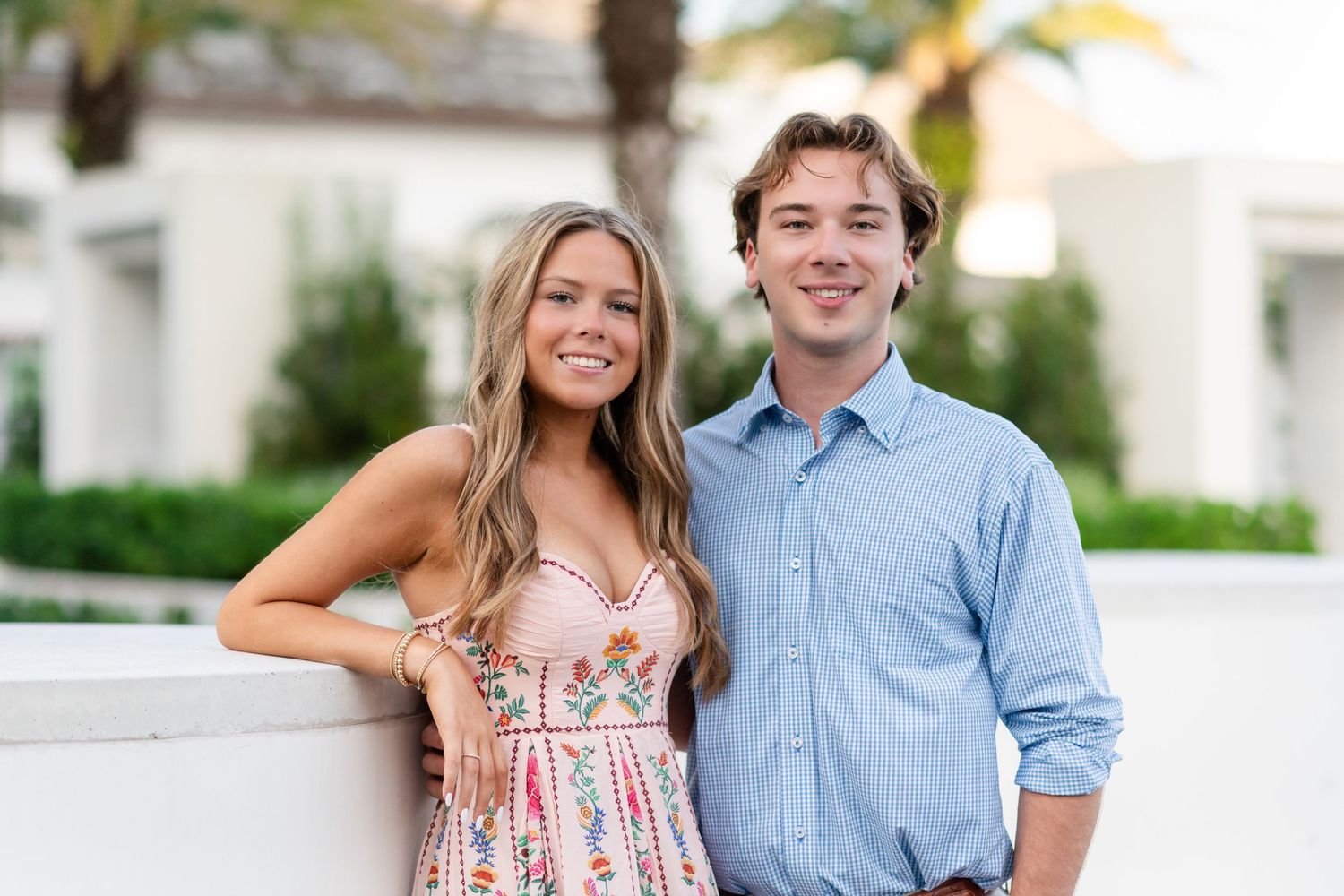 A couple poses together outdoors in coordinated casual outfits for a portrait session.