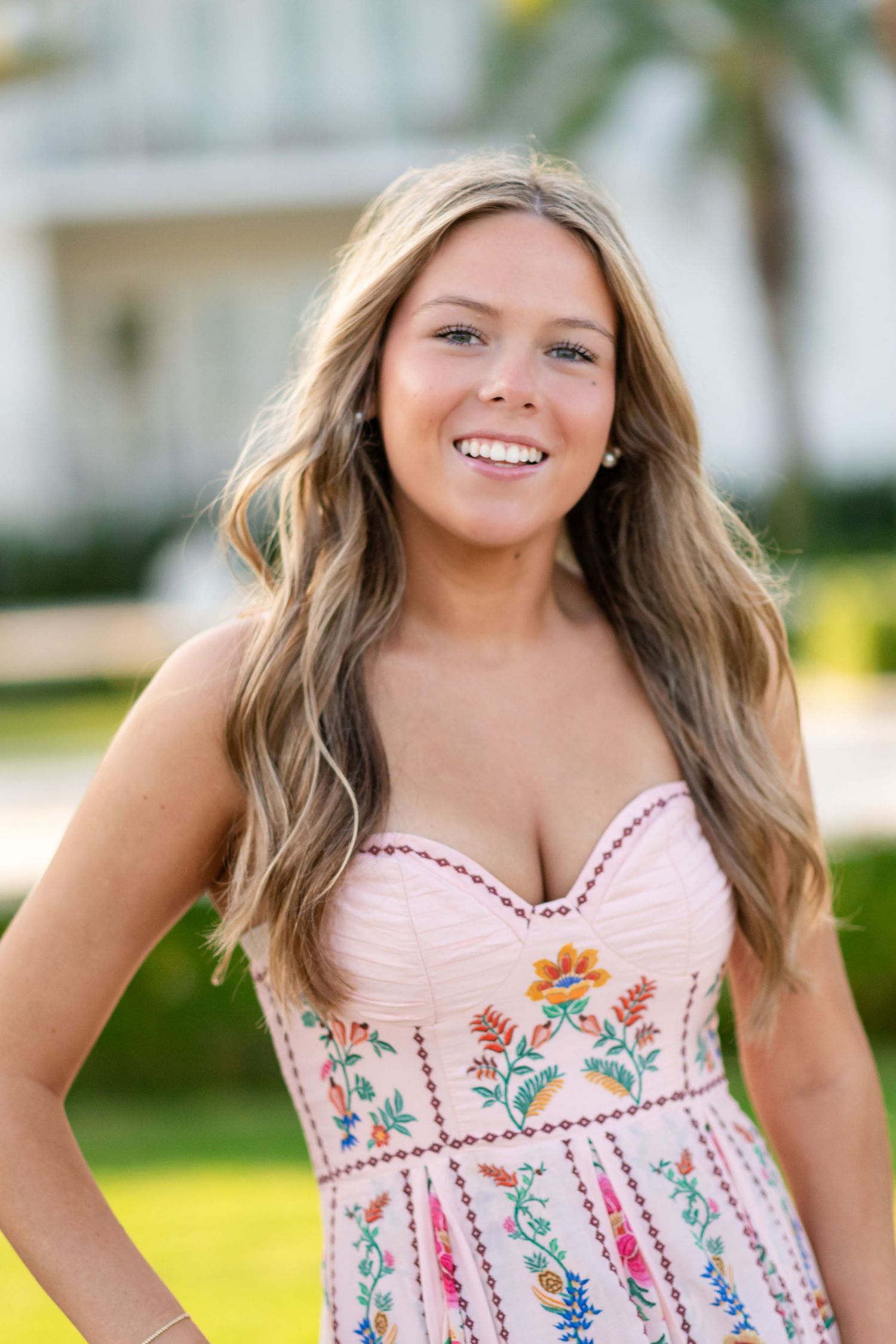 Floral sundress with pink and blue details shown in multiple close-up views against a sunny outdoor backdrop.