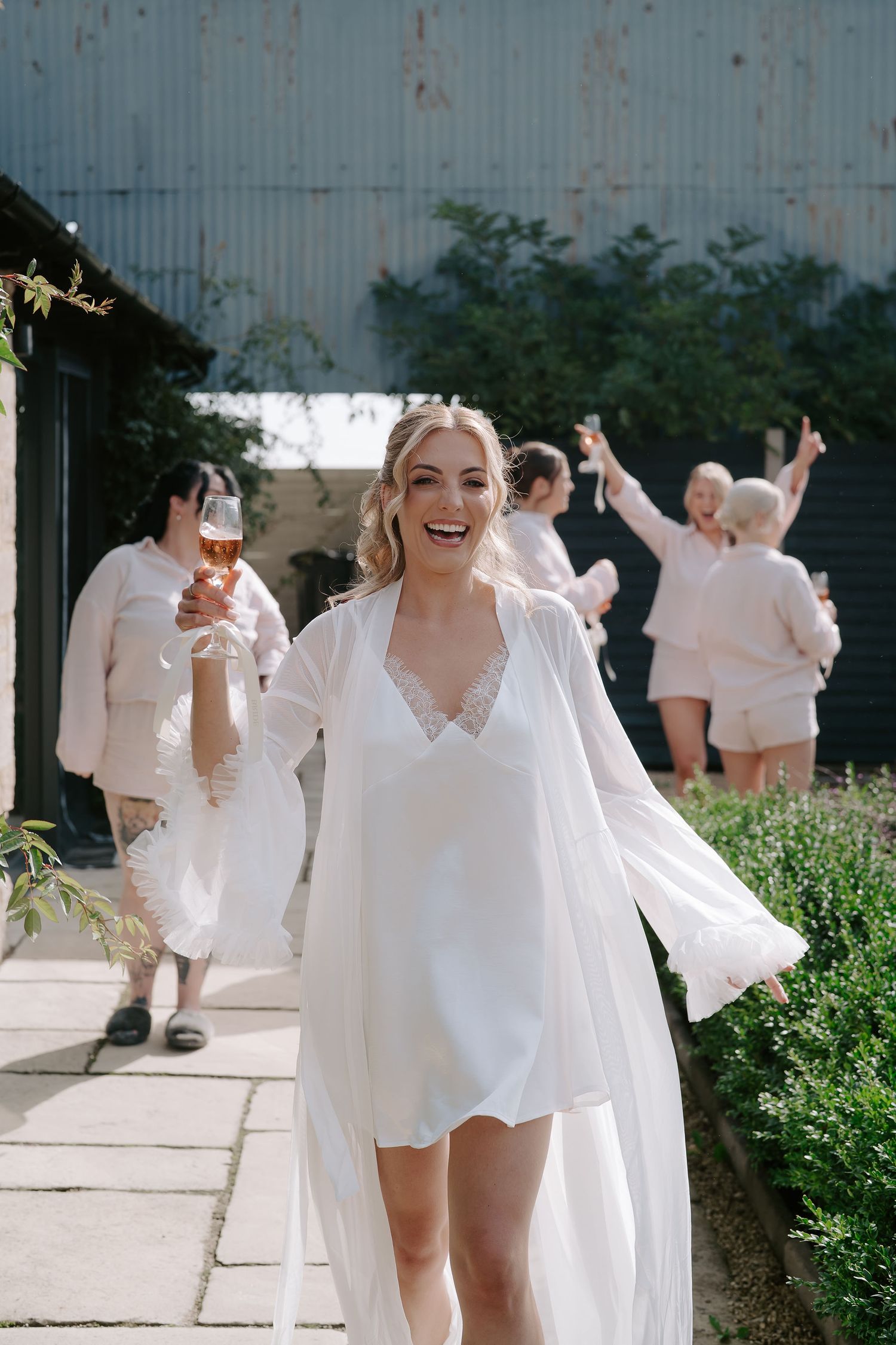bride and bridesmaids dancing and drinking champagne at ivy lodge in cirencester