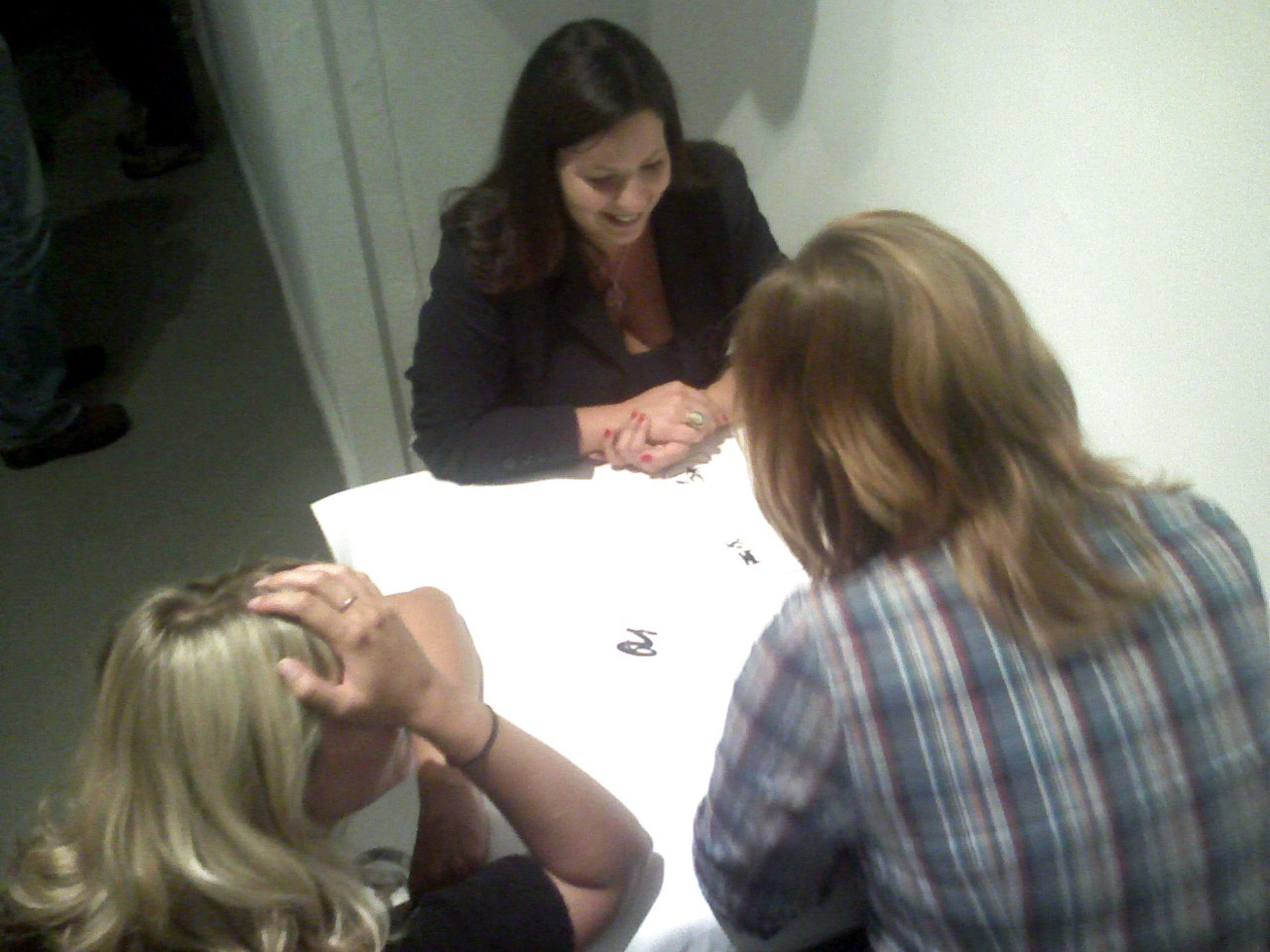 Group of people sitting at tables working on a collaborative activity in an indoor space.