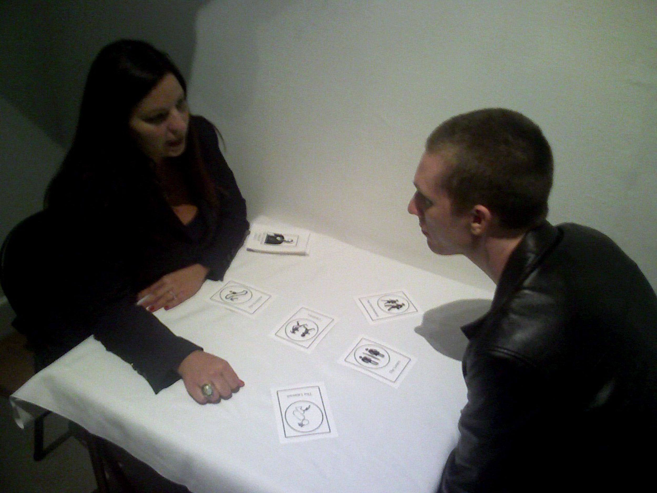 People sitting around a white table engaged in conversation or activity.