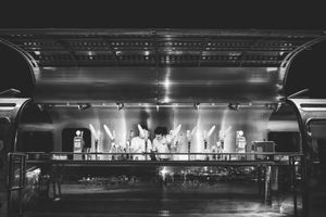 A dramatic black and white photo series showing the architectural progression of a gas station at night.