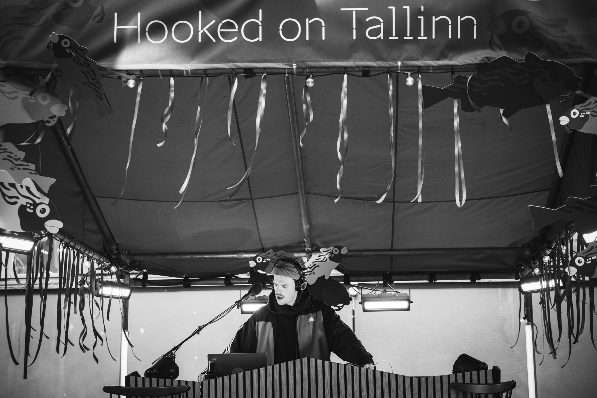 Black and white panoramic view of a banner reading 'Hooked on Tallinn' against a dark background.