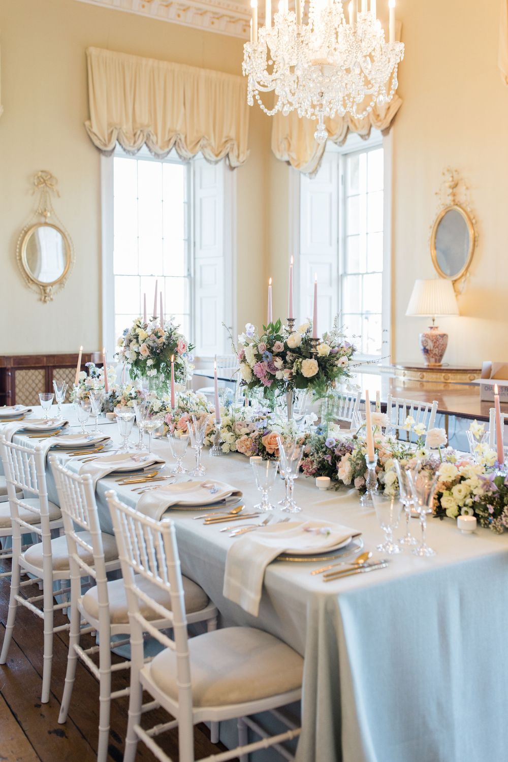 Elegant wedding tablescape with crystal chandelier, blue linens, and floral centerpieces at Botleys Mansion by Maddie Waters Photography