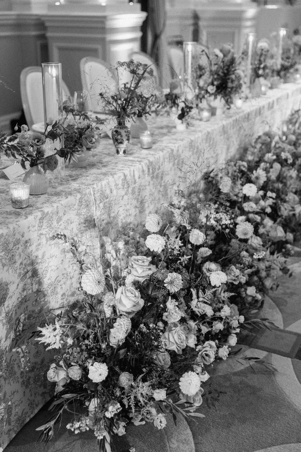 Black and white detail of luxurious floral table arrangements with roses and delicate blooms at the Corinthia London by Maddie Waters