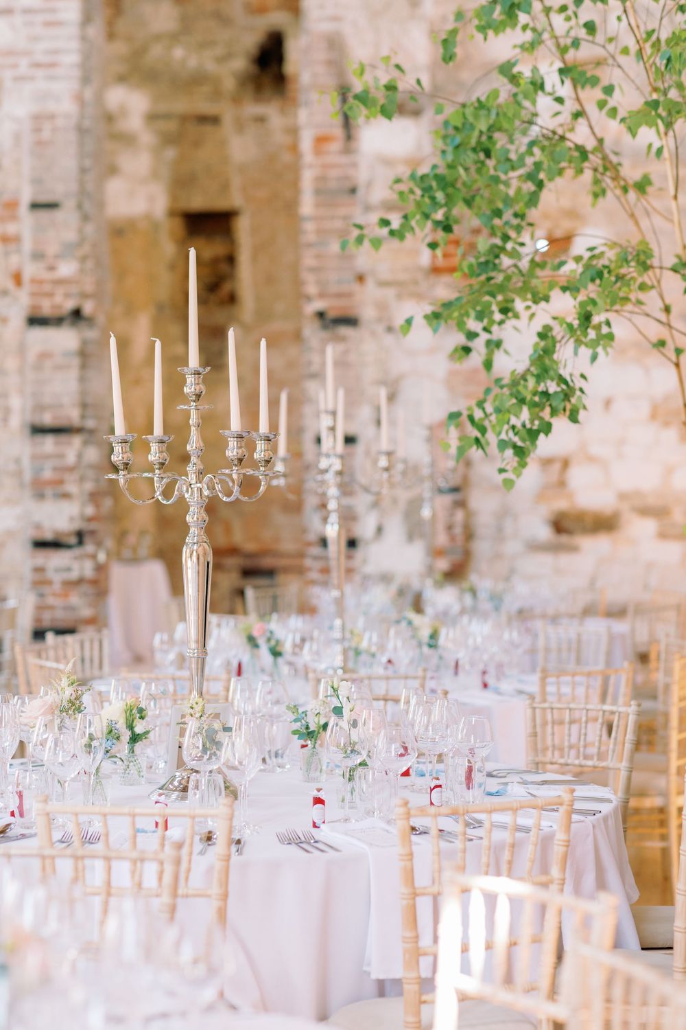 Elegant wedding reception table setup with tall silver candelabra centerpiece at Lulworth Castle by Maddie Waters Photography