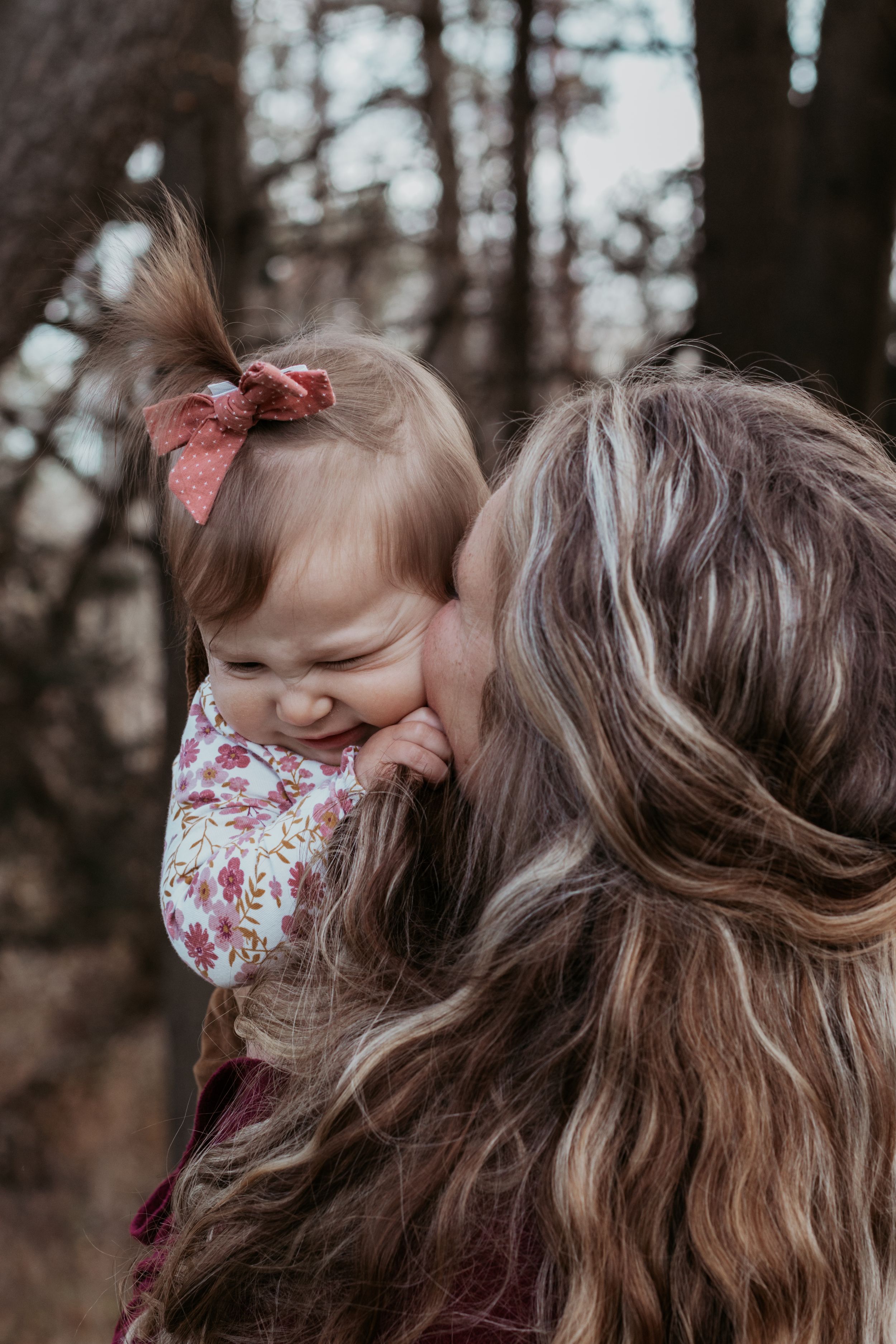Tender moment between parent and child during outdoor photo session.