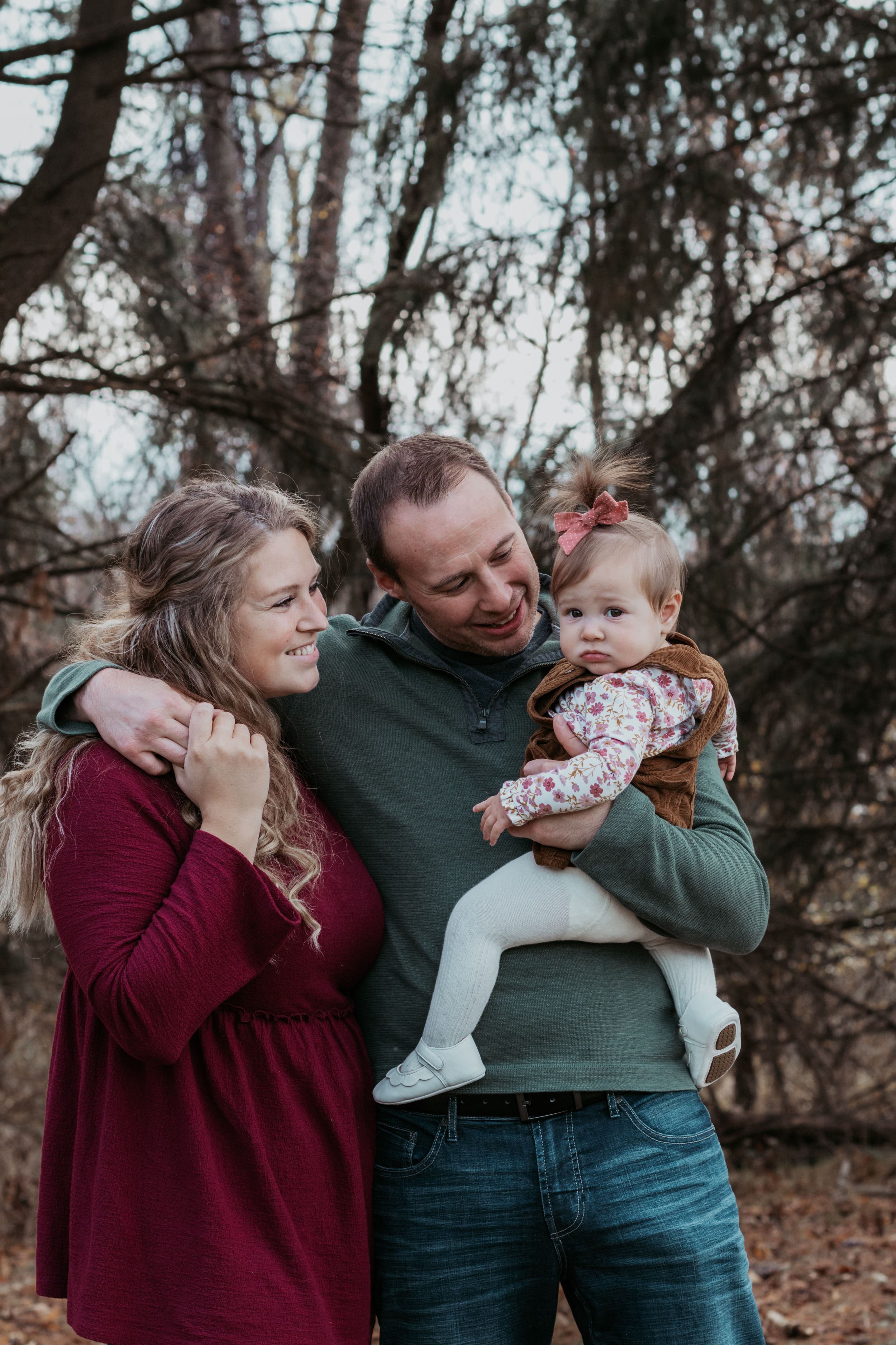 Family sharing joyful moment together during autumn outdoor photoshoot.