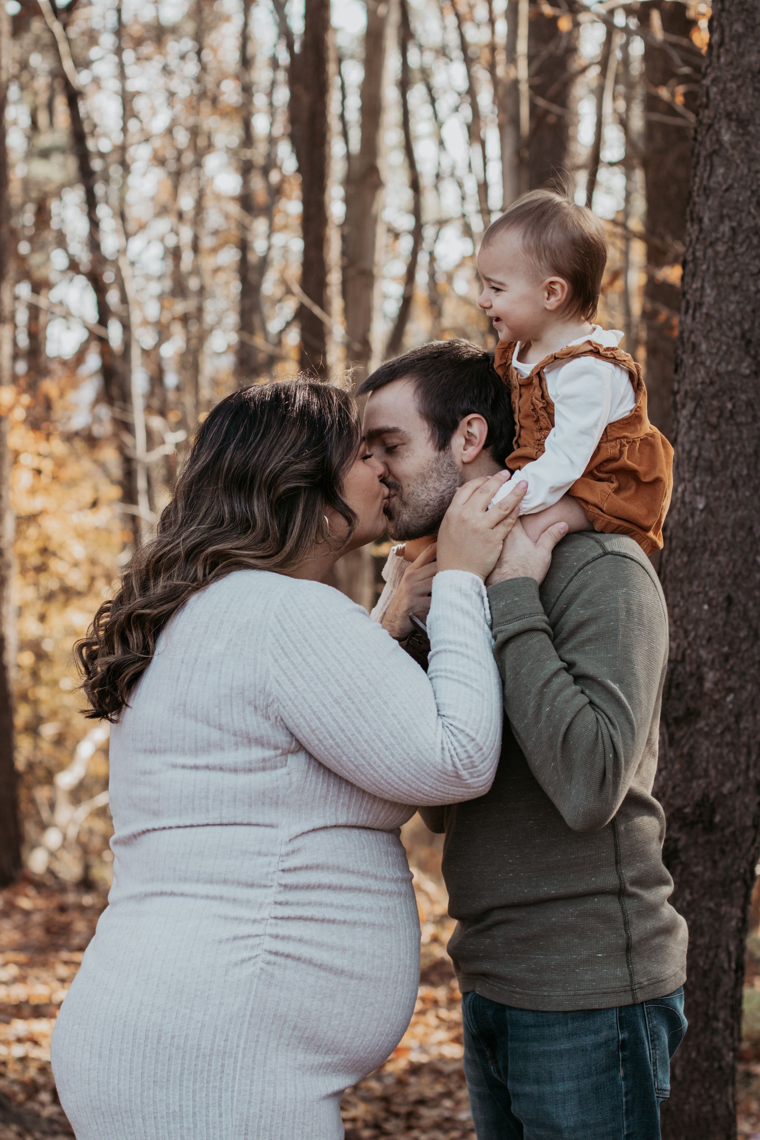 Family photoshoot in autumn forest showing tender moments with baby.