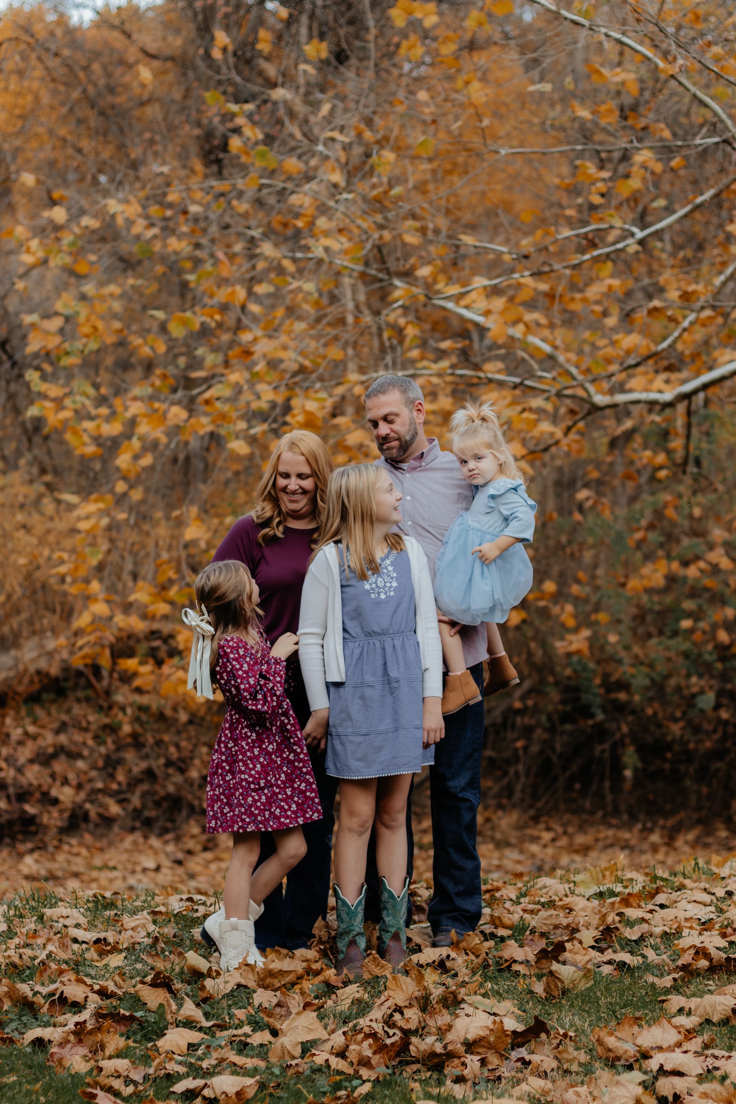 Casual family photo session in wooded area with golden fall colors.