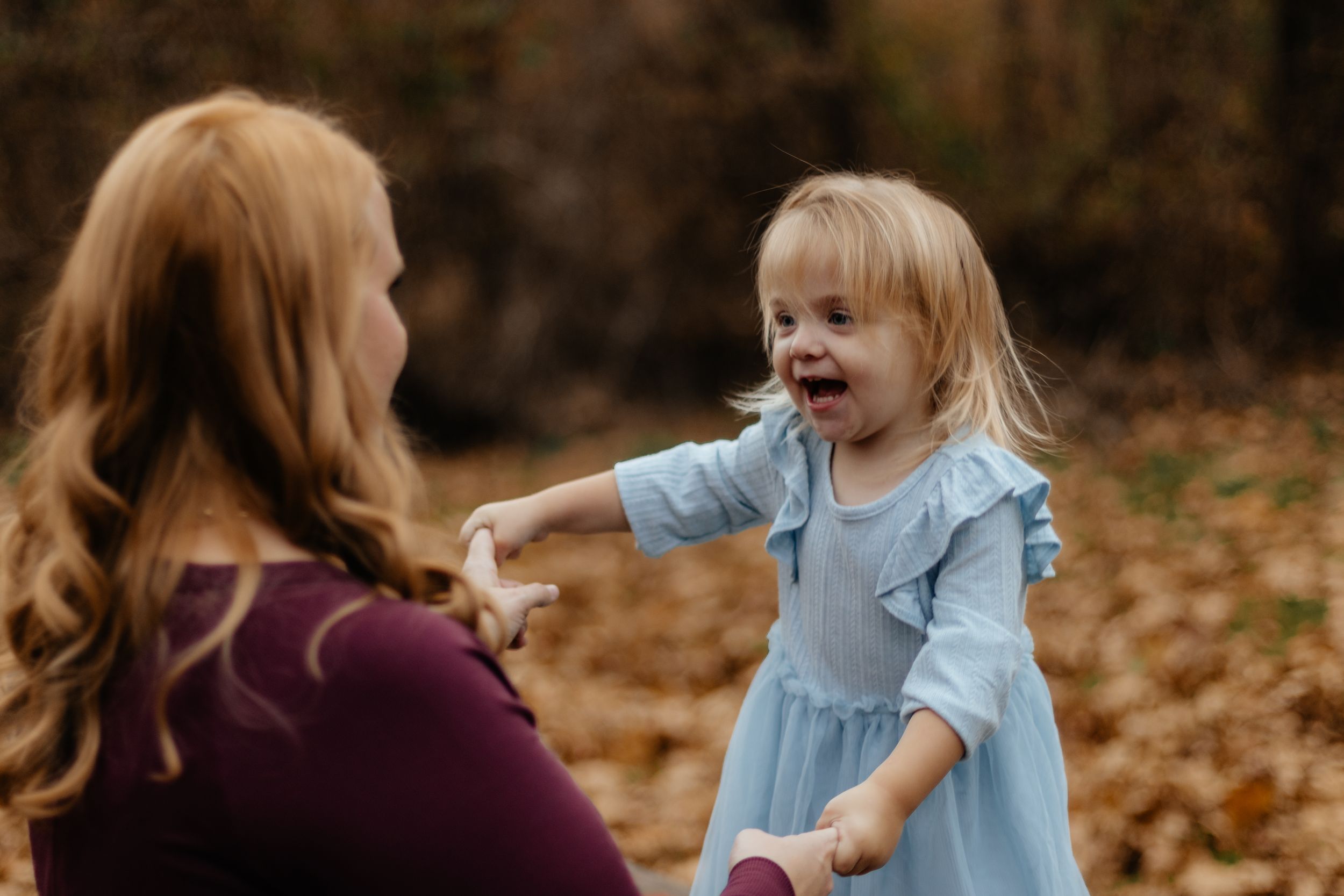 Outdoor autumn photography session featuring child in light blue dress.