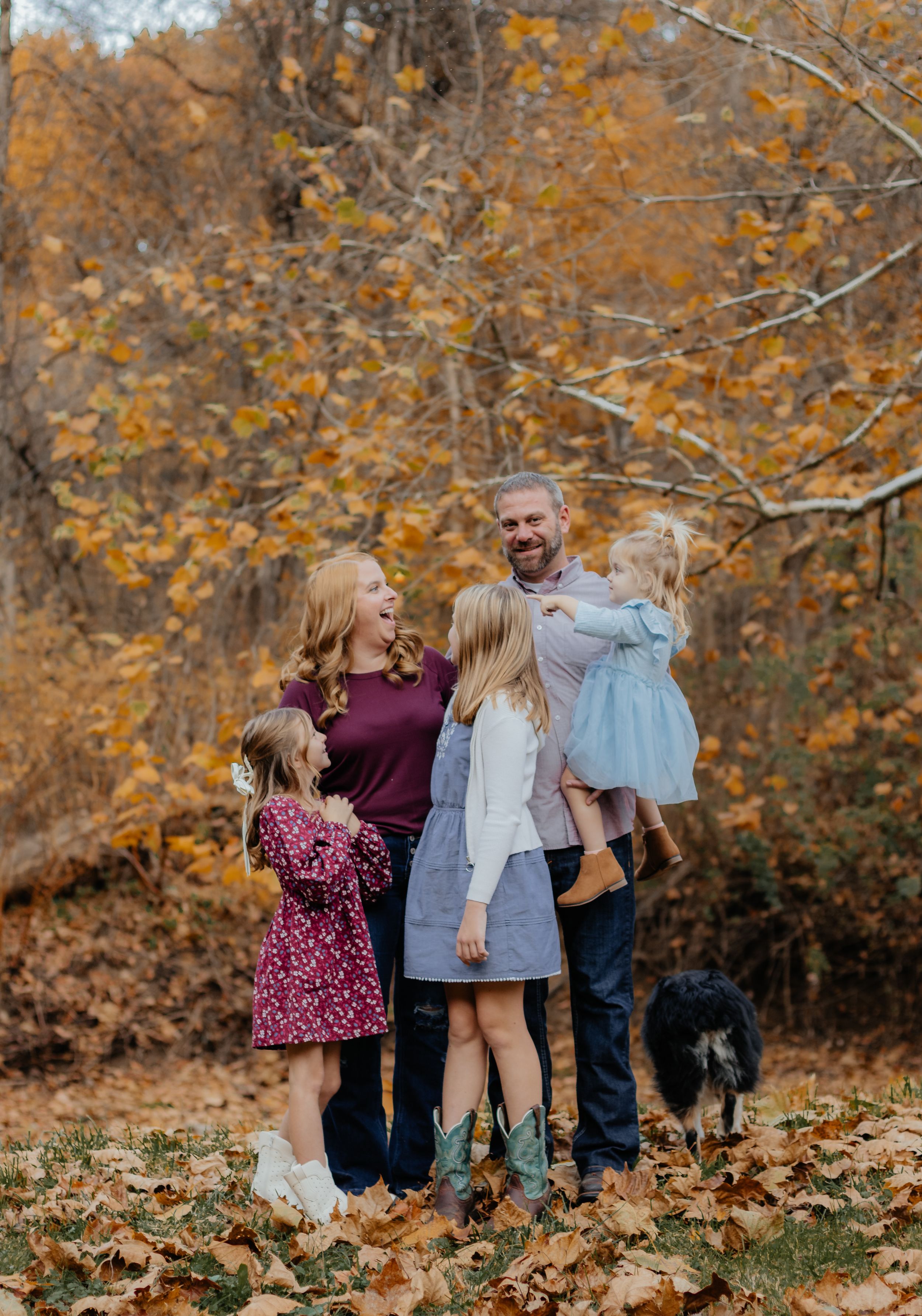 Candid family moment captured during fall photoshoot in woods.