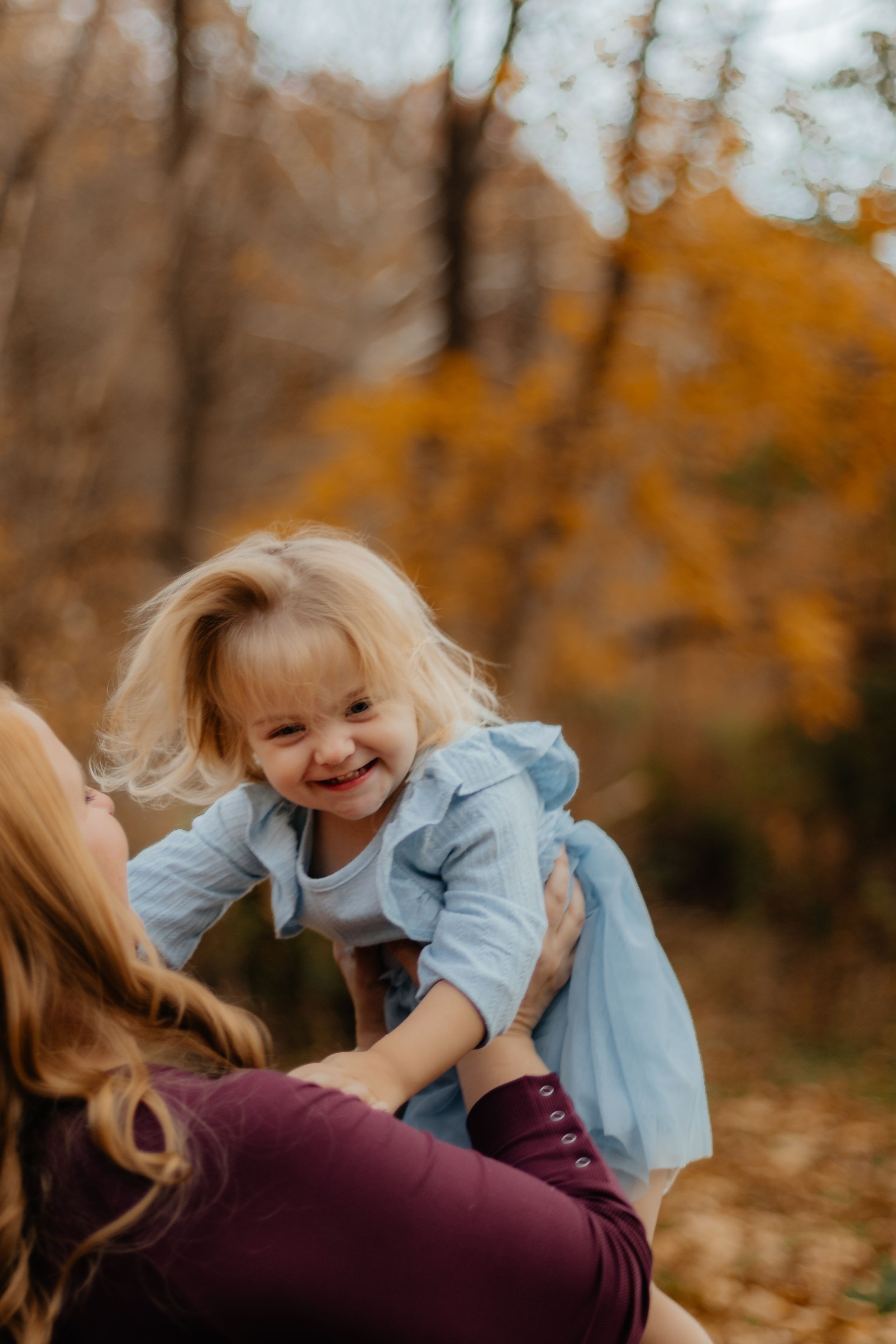 Candid playful moments photographed against a backdrop of autumn foliage.