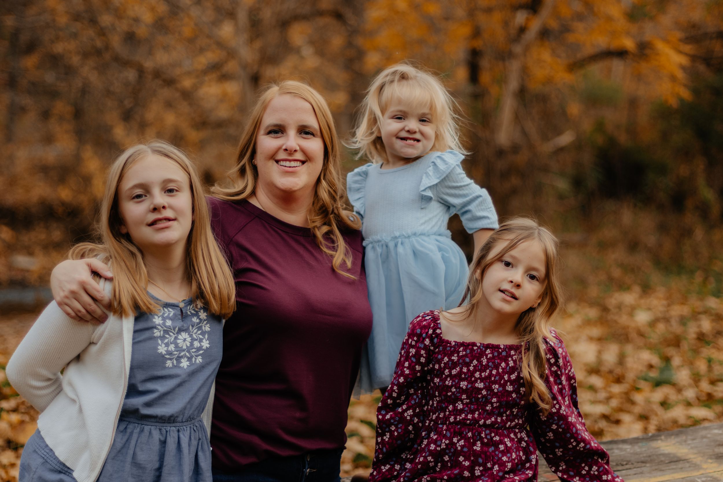 Family portrait session in a fall setting with warm autumn colors and natural lighting.