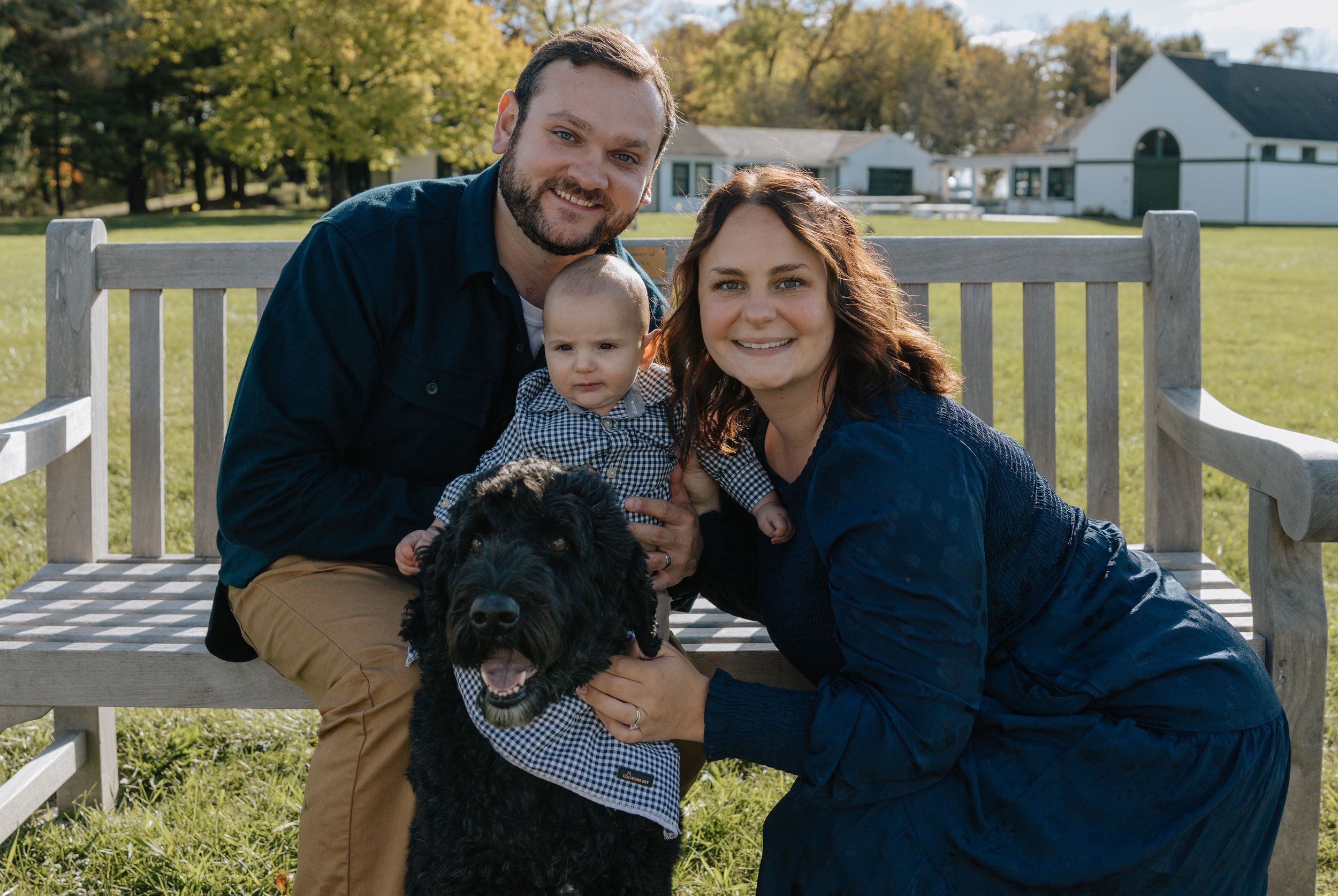 Family portrait session on a sunny autumn day with rustic white fence in the background.