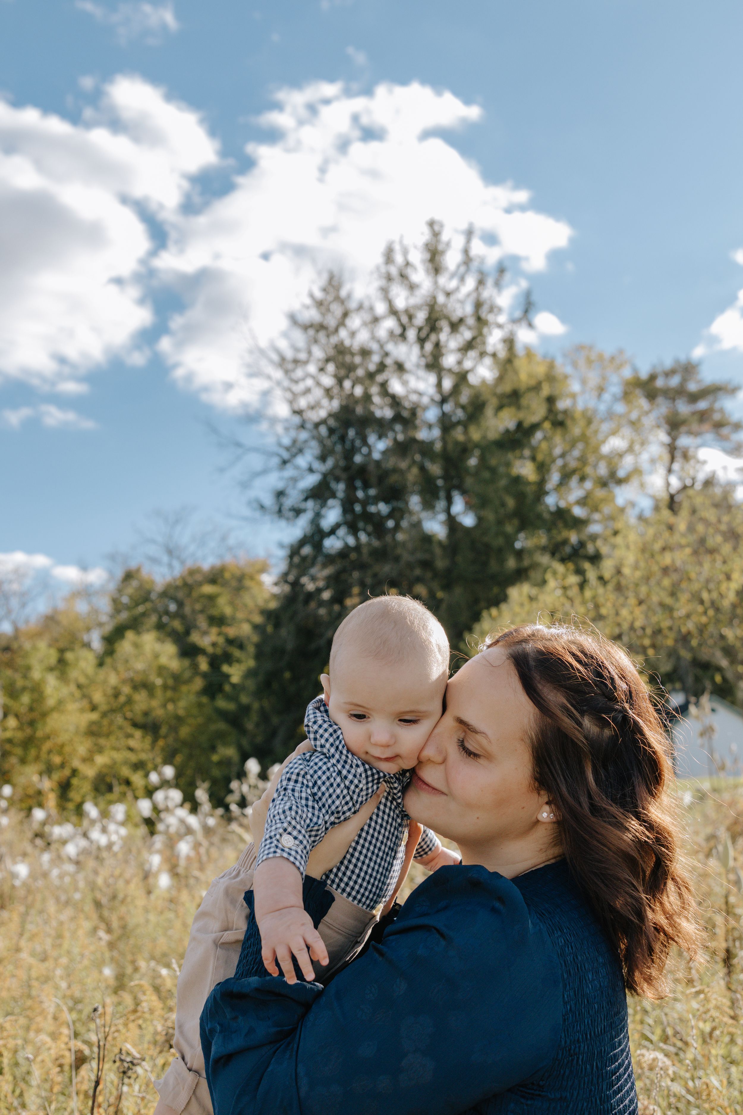 Tender outdoor family moment captured against natural autumn backdrop.