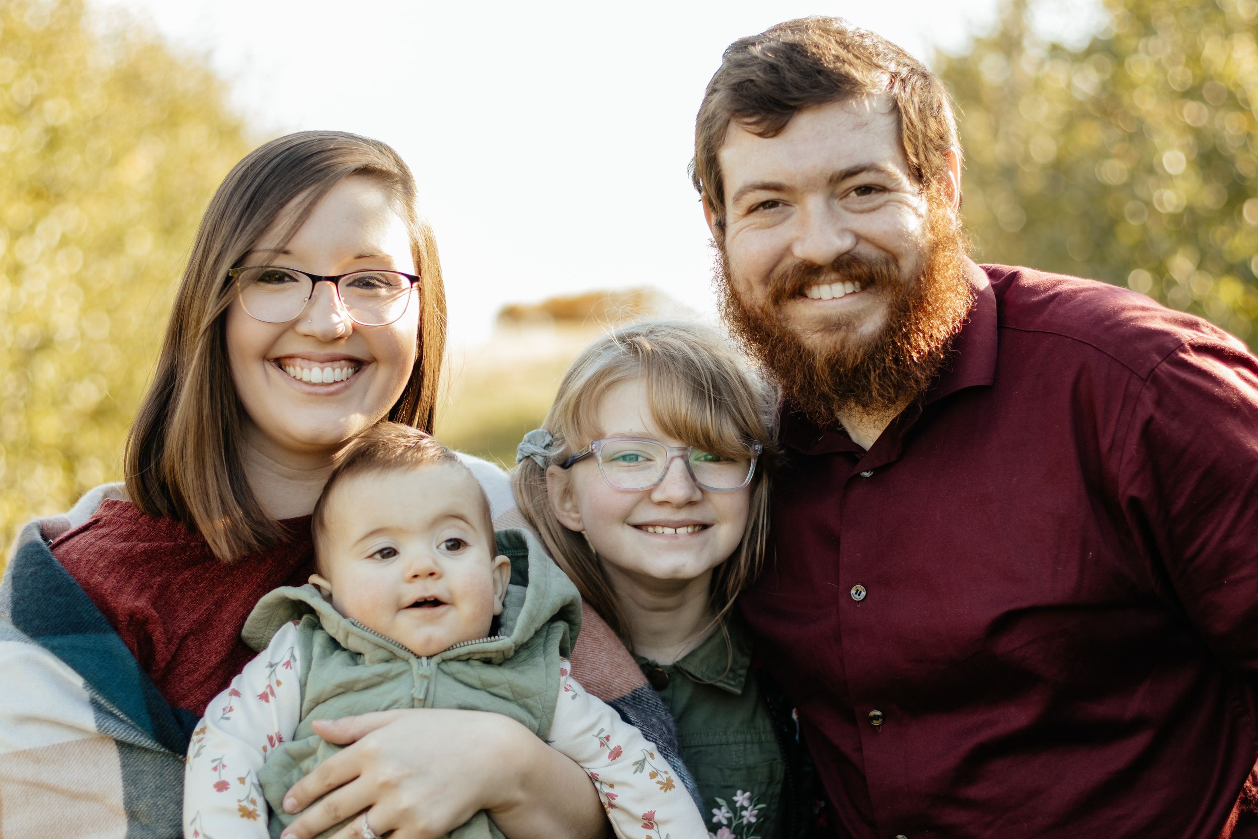 A heartwarming family portrait session with natural autumn lighting and scenery.