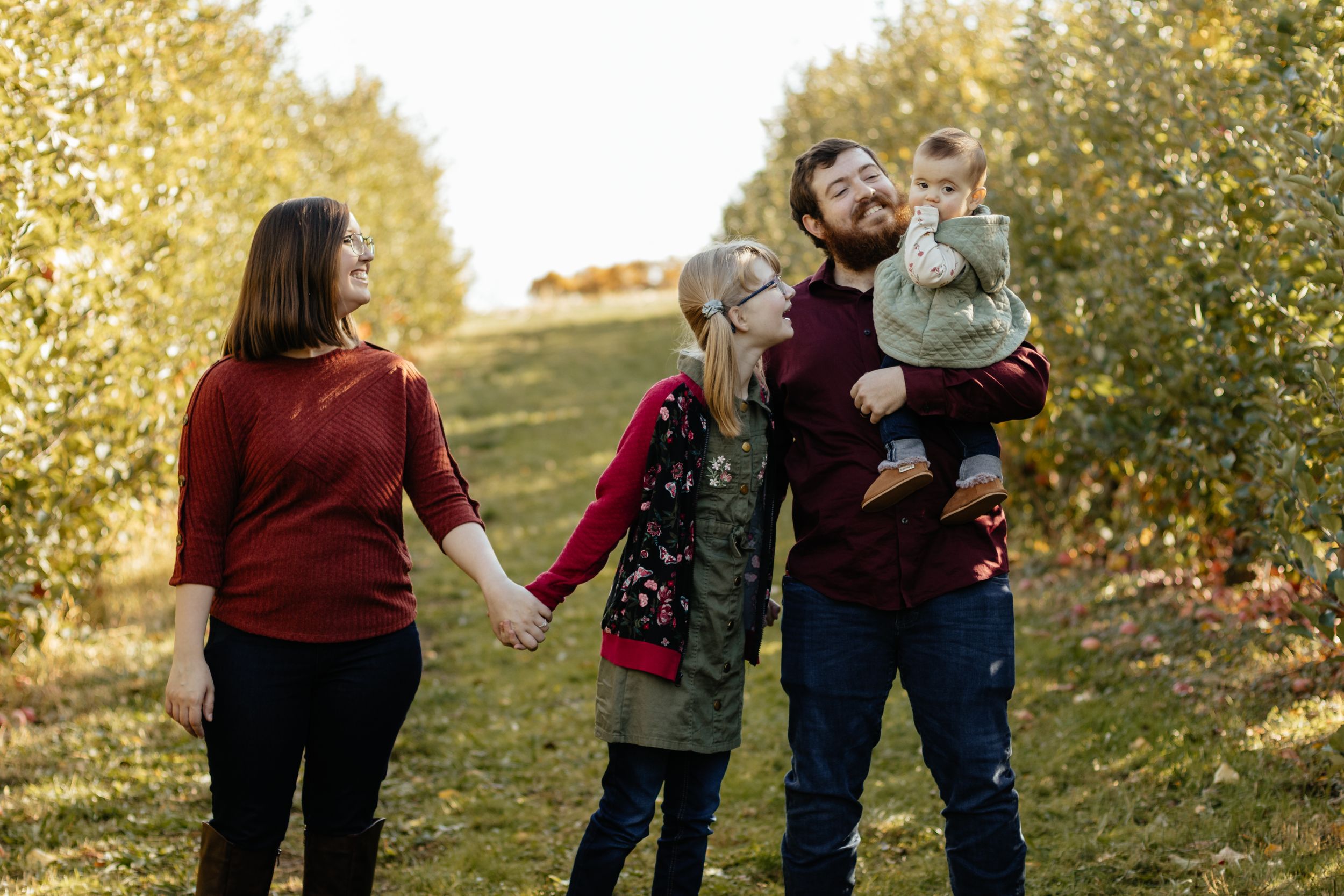 Casual outdoor family photography session with fall foliage creating a golden backdrop.