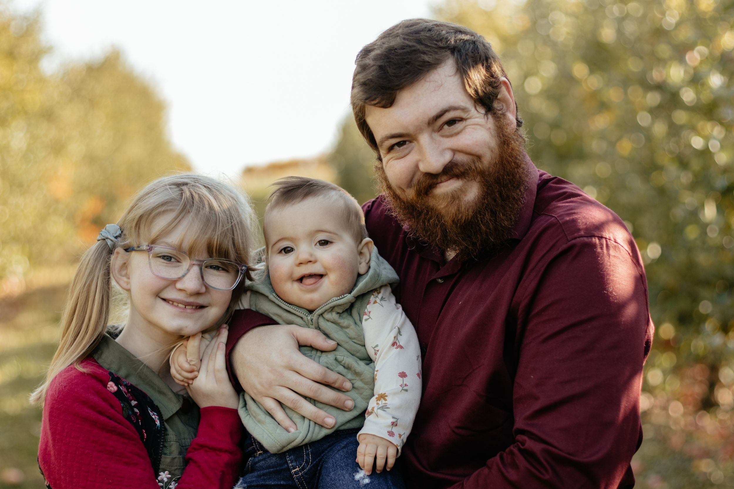 Playful family moment captured during autumn photoshoot with natural lighting.