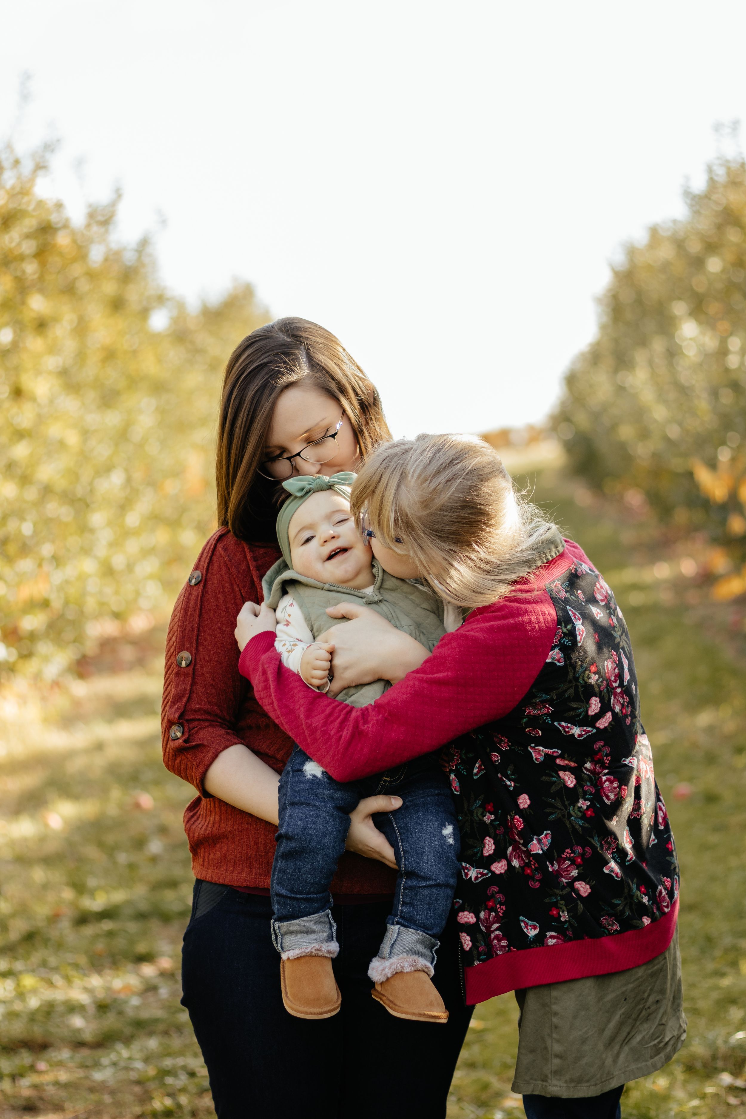 A loving embrace shared between family members during a sunny outdoor photo session.