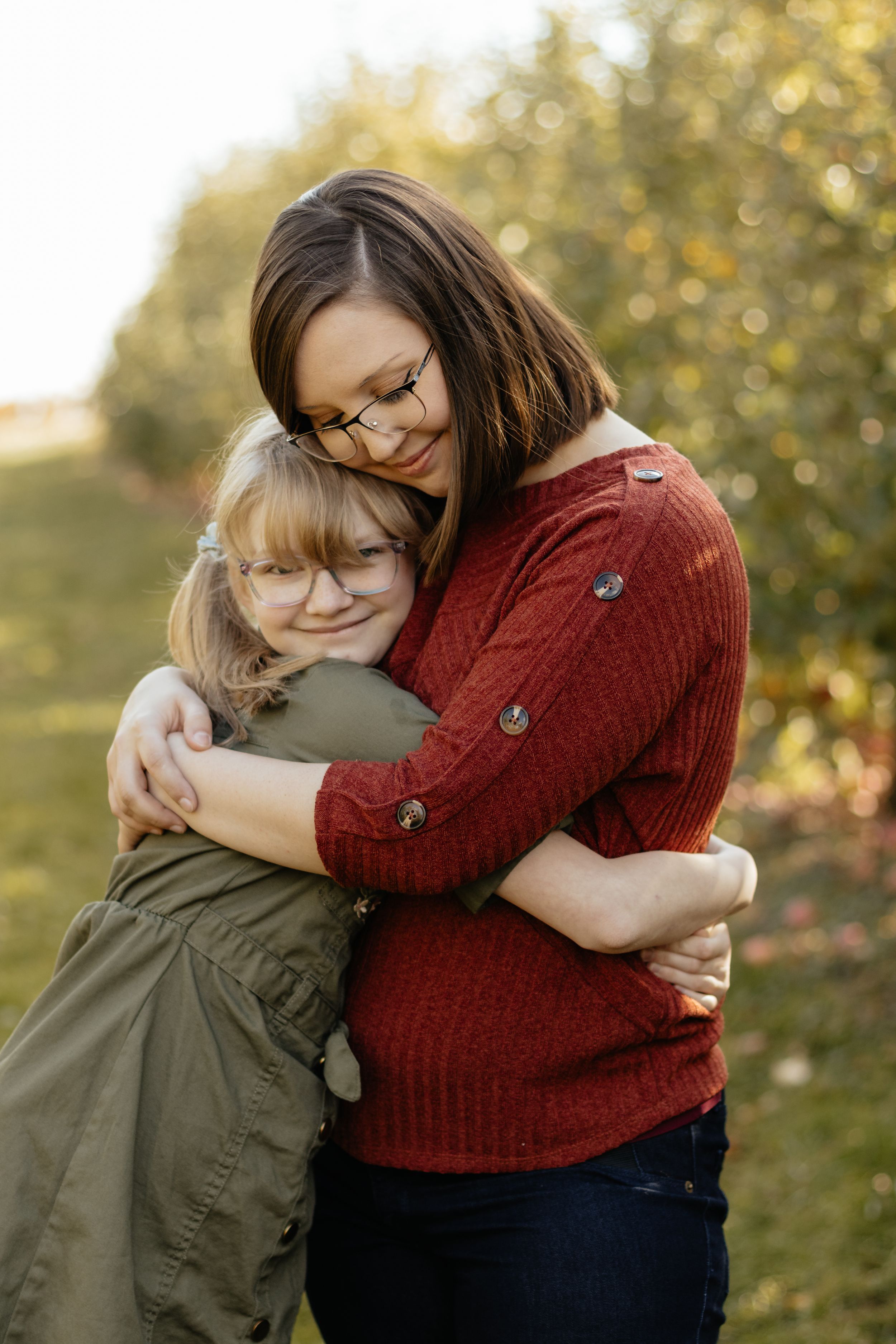 An intimate family embrace captured during a golden hour photo session outdoors.