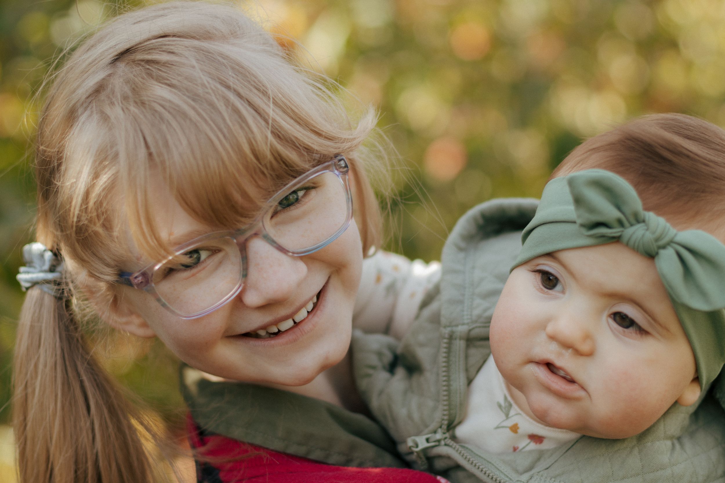 Close-up portraits showing sweet family bonding moments in natural outdoor setting.