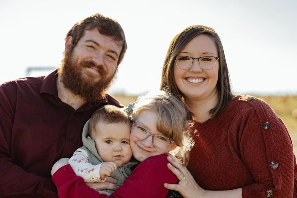 A joyful family portrait session with warm autumn colors in natural lighting.