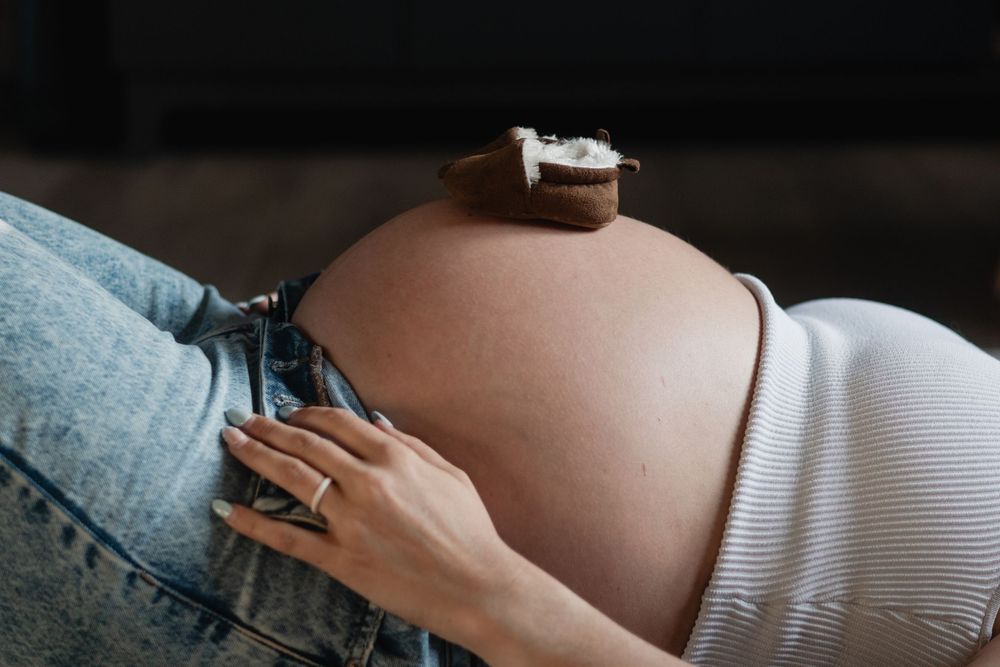 Minimalist black and white maternity photos showing pregnant belly.